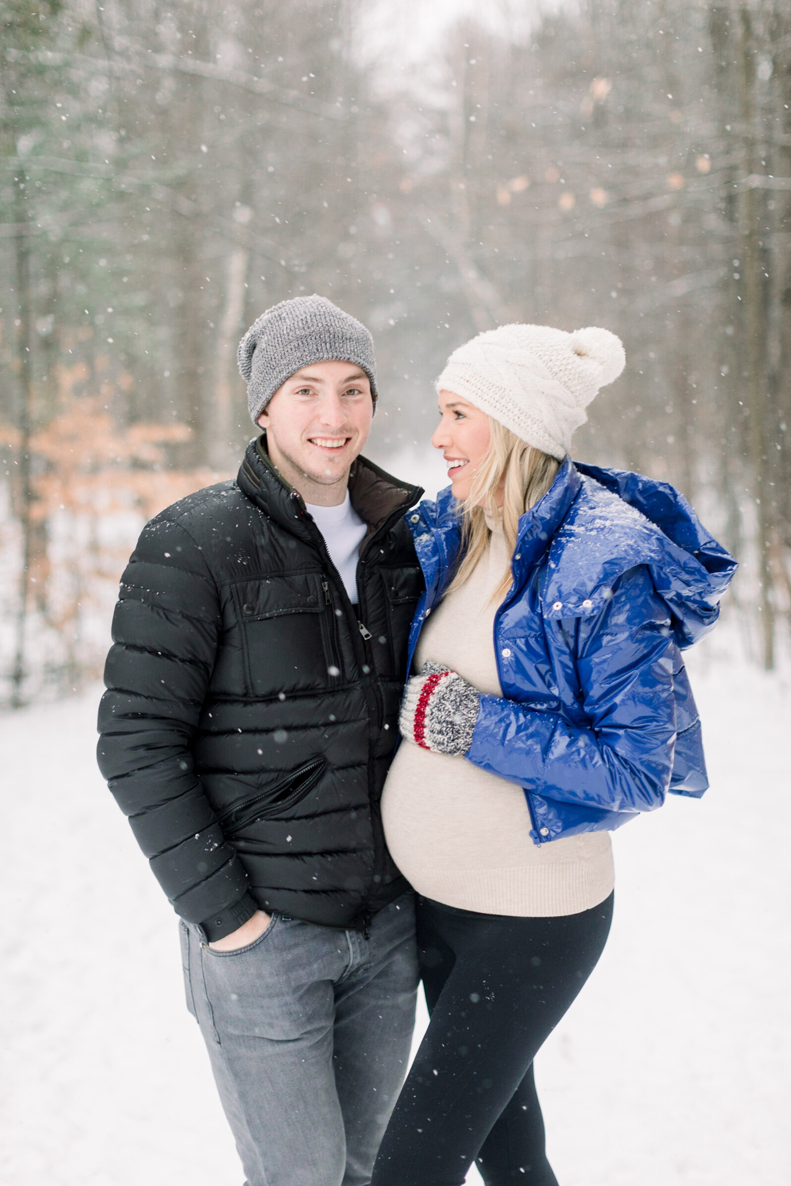  A beautiful pregnant woman looks lovingly at her husband in a winter themed maternity session in Pinhey’s Trails, Ottawa. Couple goals maternity session inspiration ideas and goals winter photo shoot inspiration ideas and goals professional maternit