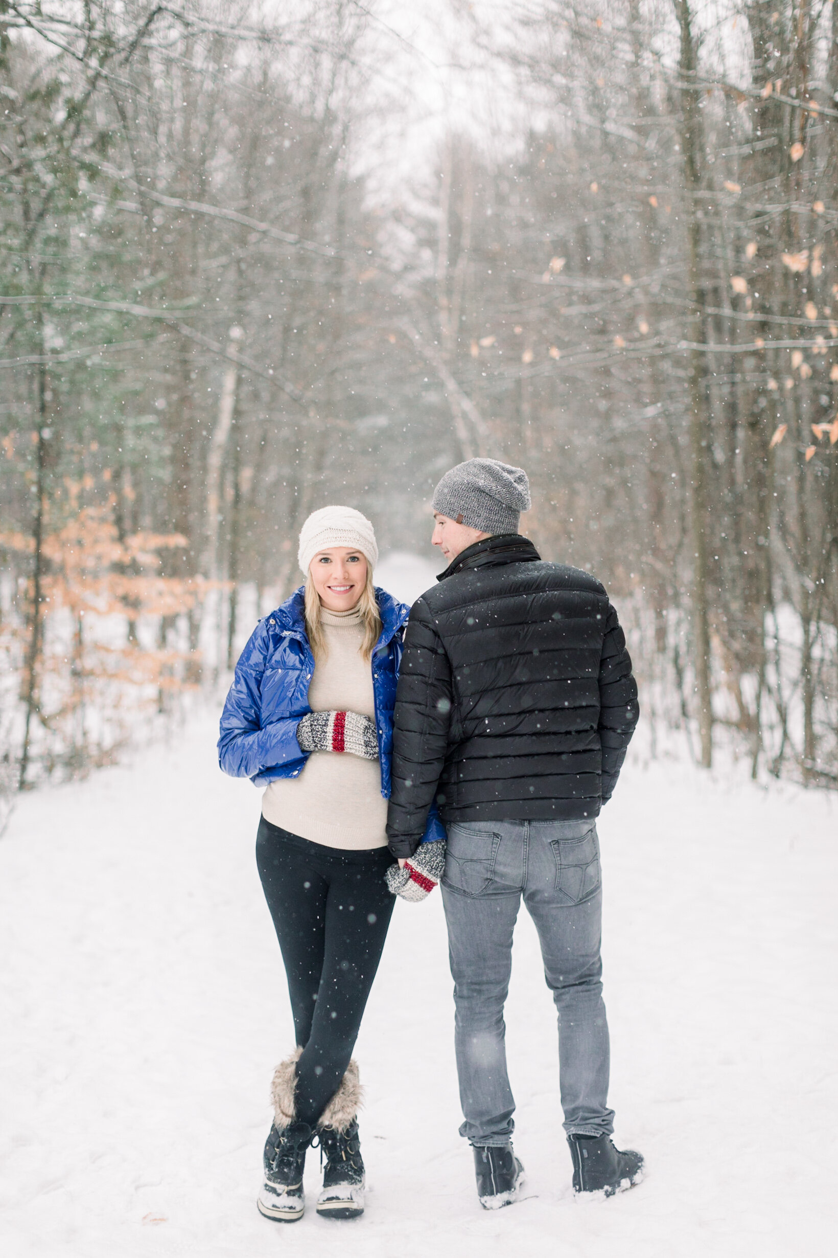  A husband and wife stand together as she rests her hand on her baby belly in a beautiful Pinhey’s Trails, Ottawa maternity session by professional photographer Chelsea Mason Photography. Couple pose inspiration couple goals client attire inspiration