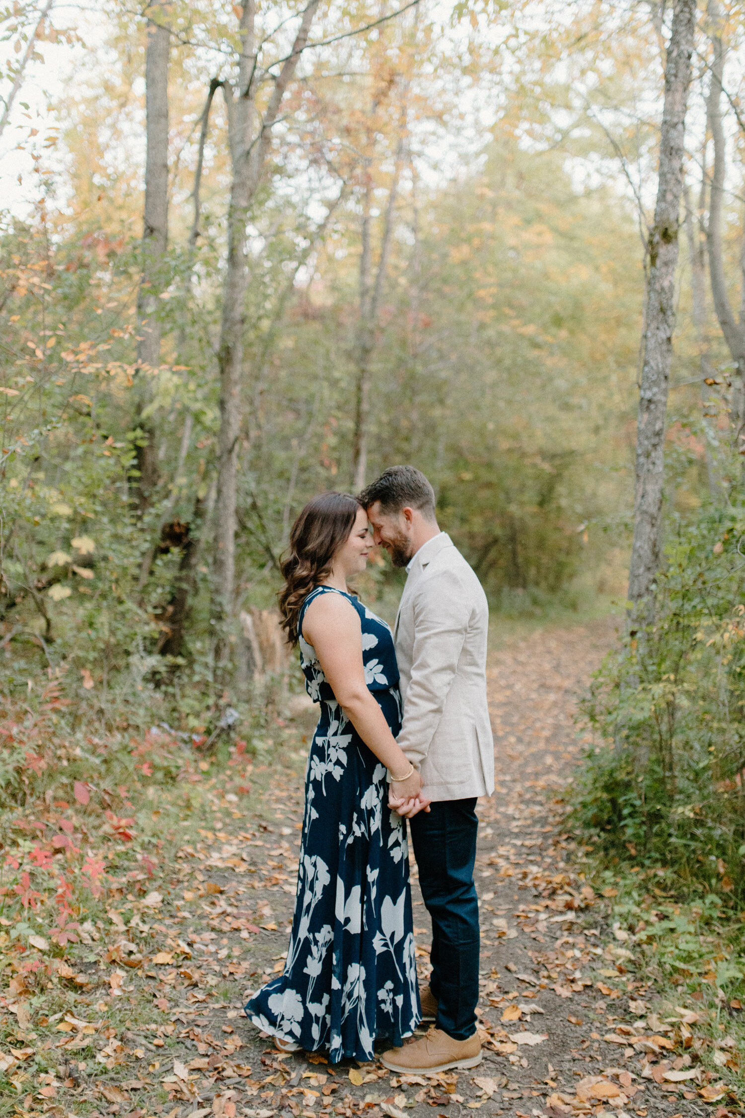  During this wooded outdoor engagement session in Ontario, Canada, Chelsea Mason Photography captures this couple romantically pressing their foreheads together and holding hands. Ontario canada engagement photographer, wooded outdoor autumn canadian