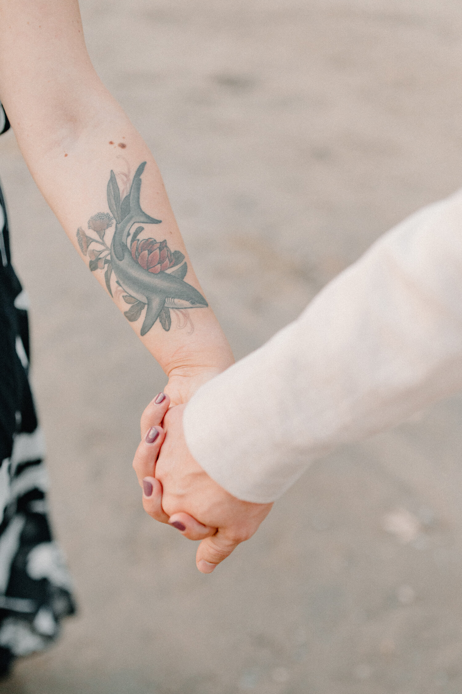  During this Ottawa, Canada engagement session, Chelsea Mason Photography captures an up-close shot of this couple holding hands along the beach, featuring this woman’s shark tattoo on her forearm. Womens forearm tattoo, shark tattoo with flowers, co
