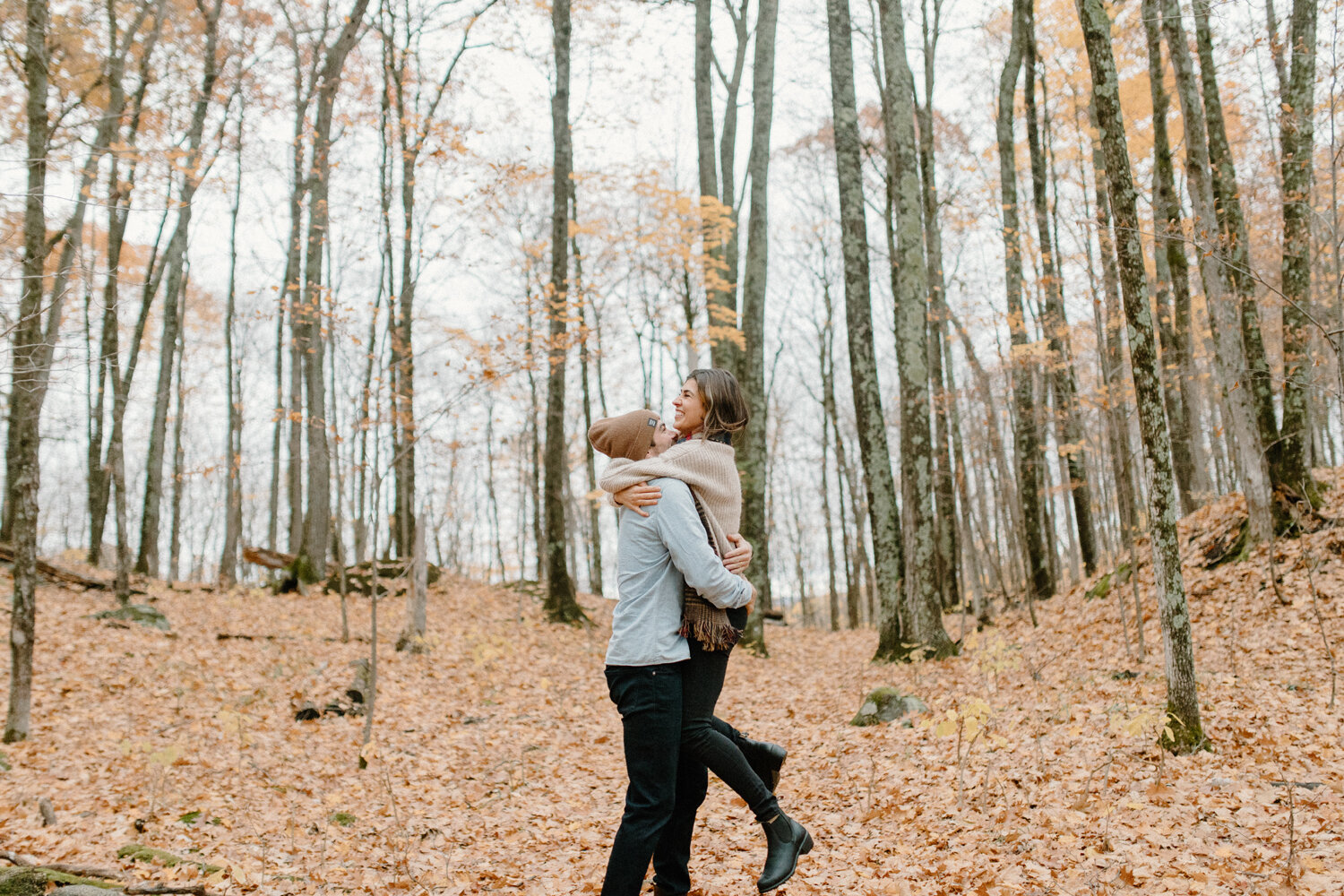  Quebec, Canada’s Chelsea Mason Photography captures this energetic couple lifting one another and laughing during their autumn engagement session in the forrest. Forrest canadian engagement session, man lifting woman with woman lifting her feet, man
