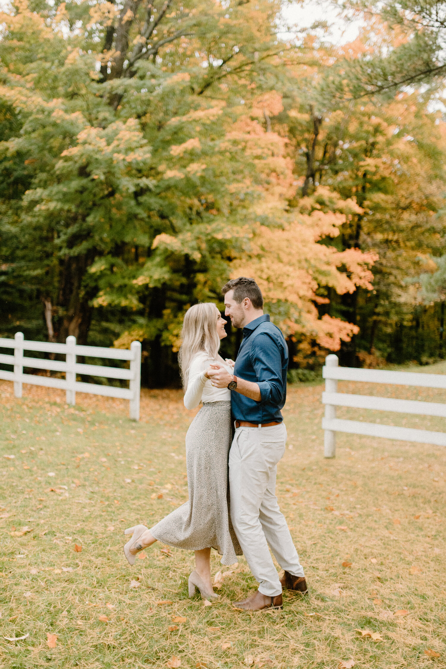  Quebec, Canada engagement photographer, Chelsea Mason Photography captures this engaged couple smiling and holding hands during their autumn engagements. cream and navy colored engagement outfit, long medium blonde womens loose curled hair, womens t