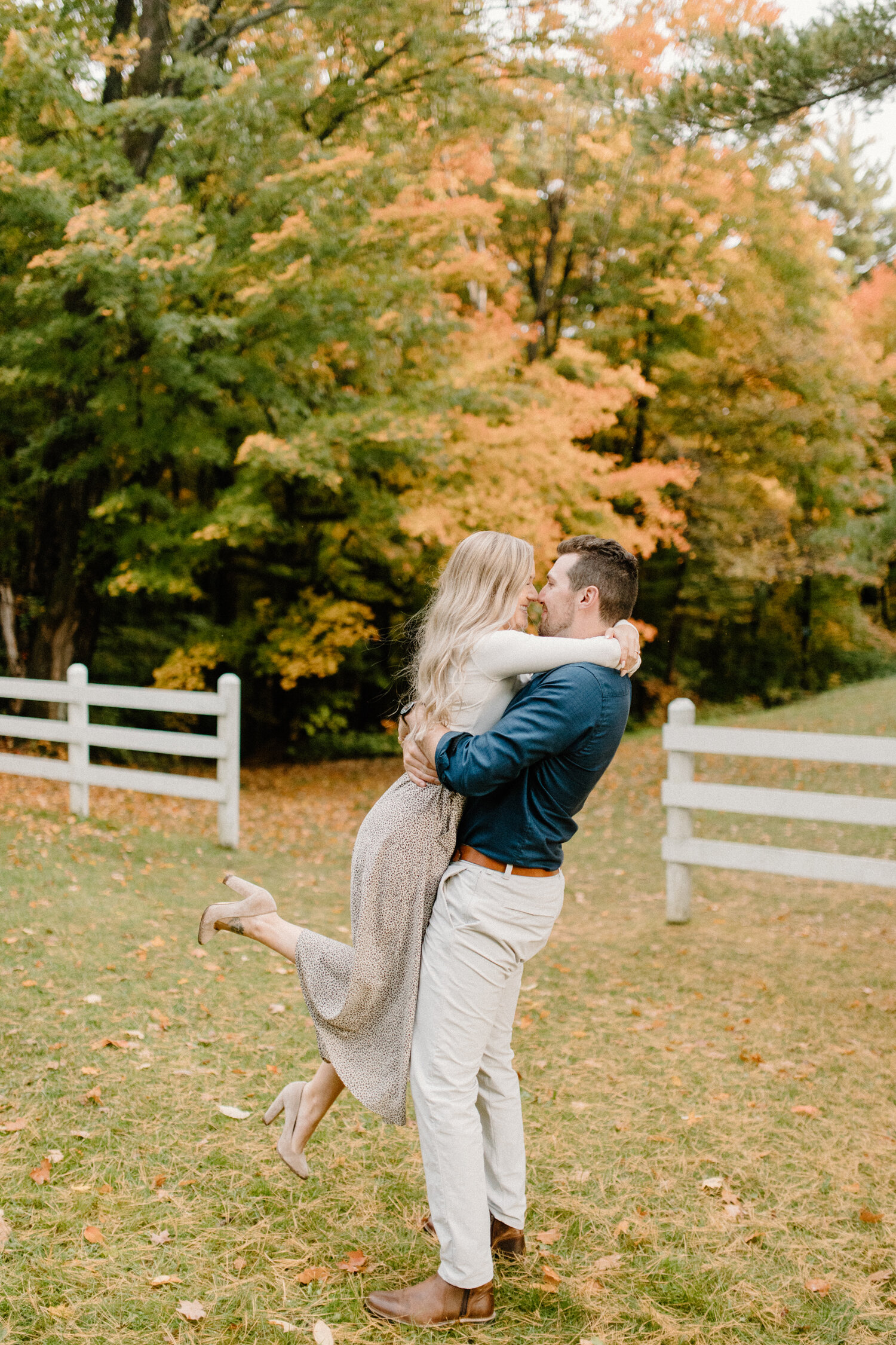  During this playful Ottawa, Canada engagement session, Chelsea Mason Photography captures this groom holding his bride while she wraps her arms around his neck. playful engagement session poses, groom holding bride, long medium blonde womens loose c