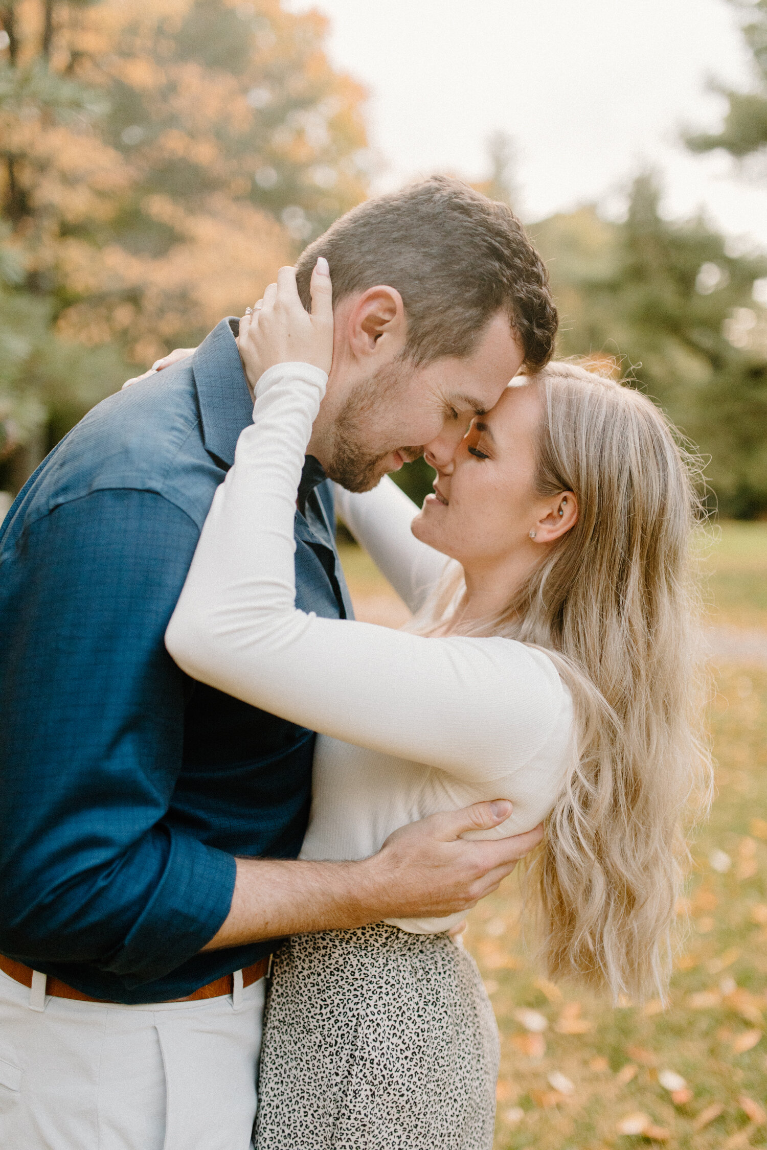  During this autumn engagement session in Quebec, Canada, Chelsea Mason Photography captures a tender moment between this couple as they embrace and press their foreheads together. man leaning down to press forehead against wife, long womens medium b