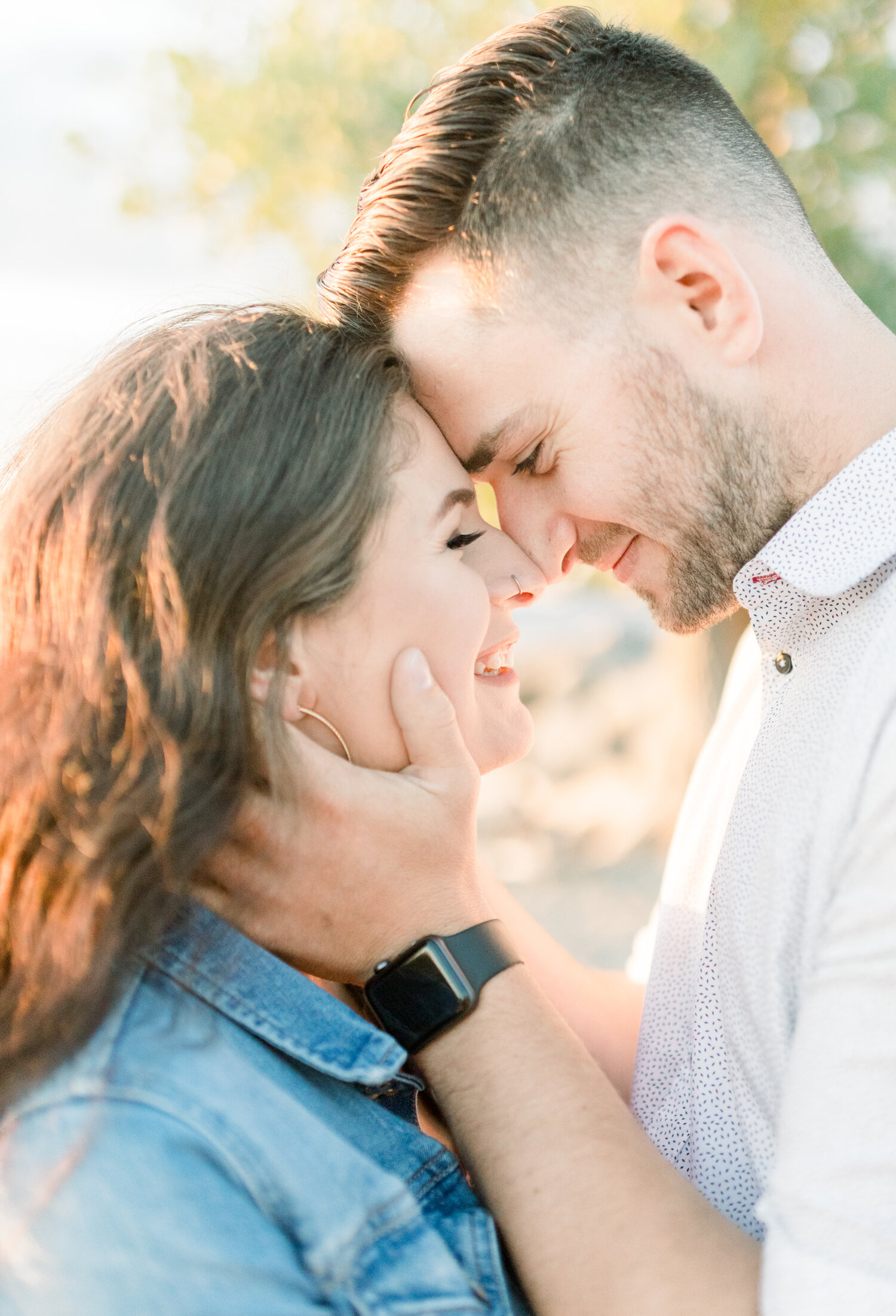  During this couple’s maternity session in Ottawa, Canada, Chelsea Mason Photography captures a tender moment between these expectant parents as they press their foreheads together. womens nose ring. womens denim jacket, mens black apple watch, mens 
