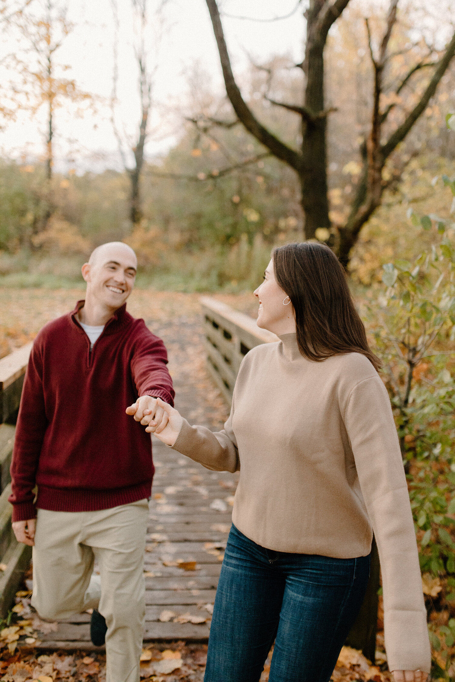  During this crisp autumn engagement session, Chelsea Mason Photography captures this fiance taking her soon-to-be groom’s hand and leading him through a shaded pathway in Ottawa, Canada. autumn engagement session in ottawa canada photographer womens