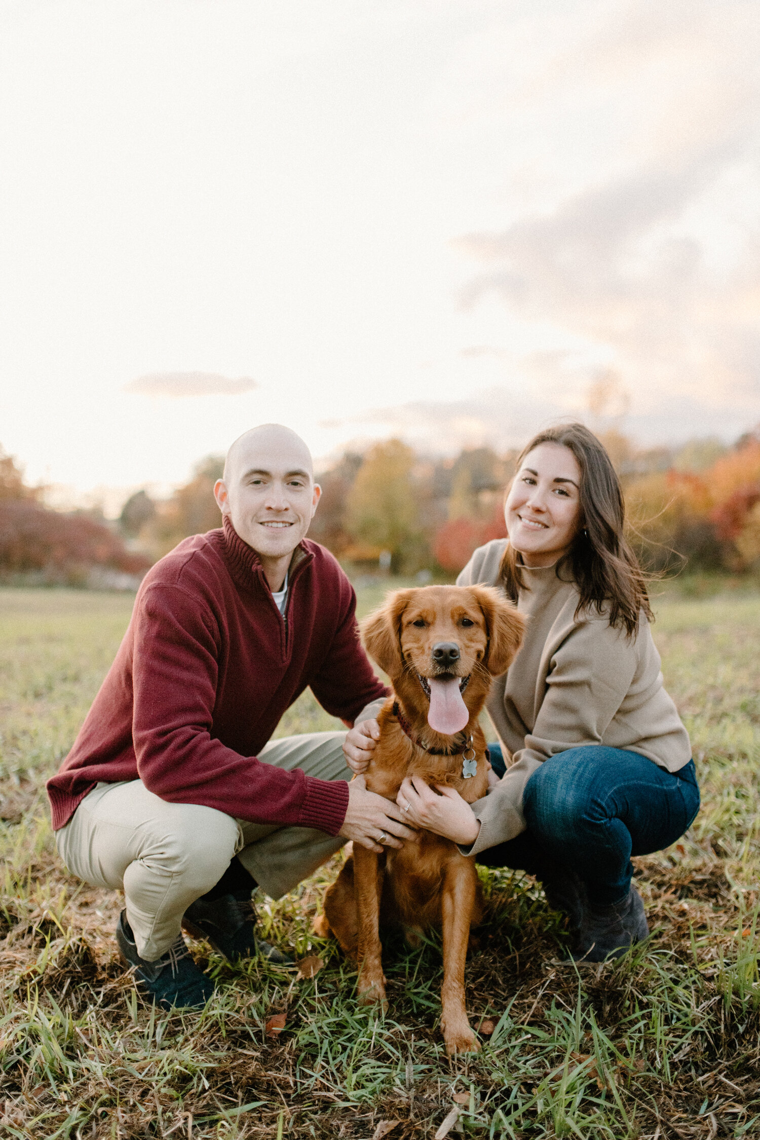  During their autumn engagement session in Ottawa, Canada, this couple poses with their medium brown golden retriever dog for Chelsea Mason Photography. dog included in family photos medium brown colored golden retriever autumn colored engagement out