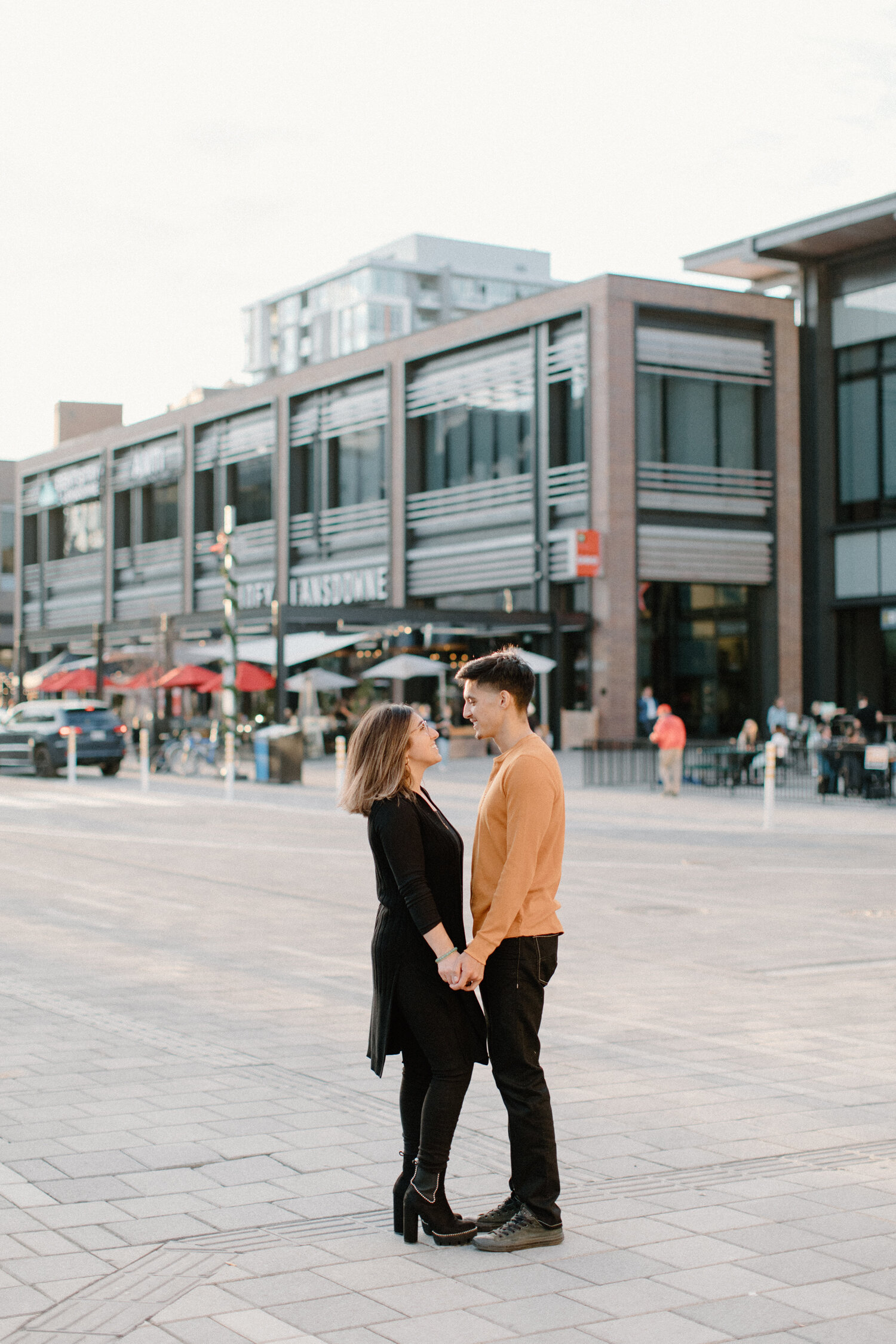  Ottawa, Canada photographer, Chelsea Mason Photography captures this couple holding hands in an urban setting during their engagement session. black and orange family photo outfit color scheme engagement outfit inspiration couple holding hands and l
