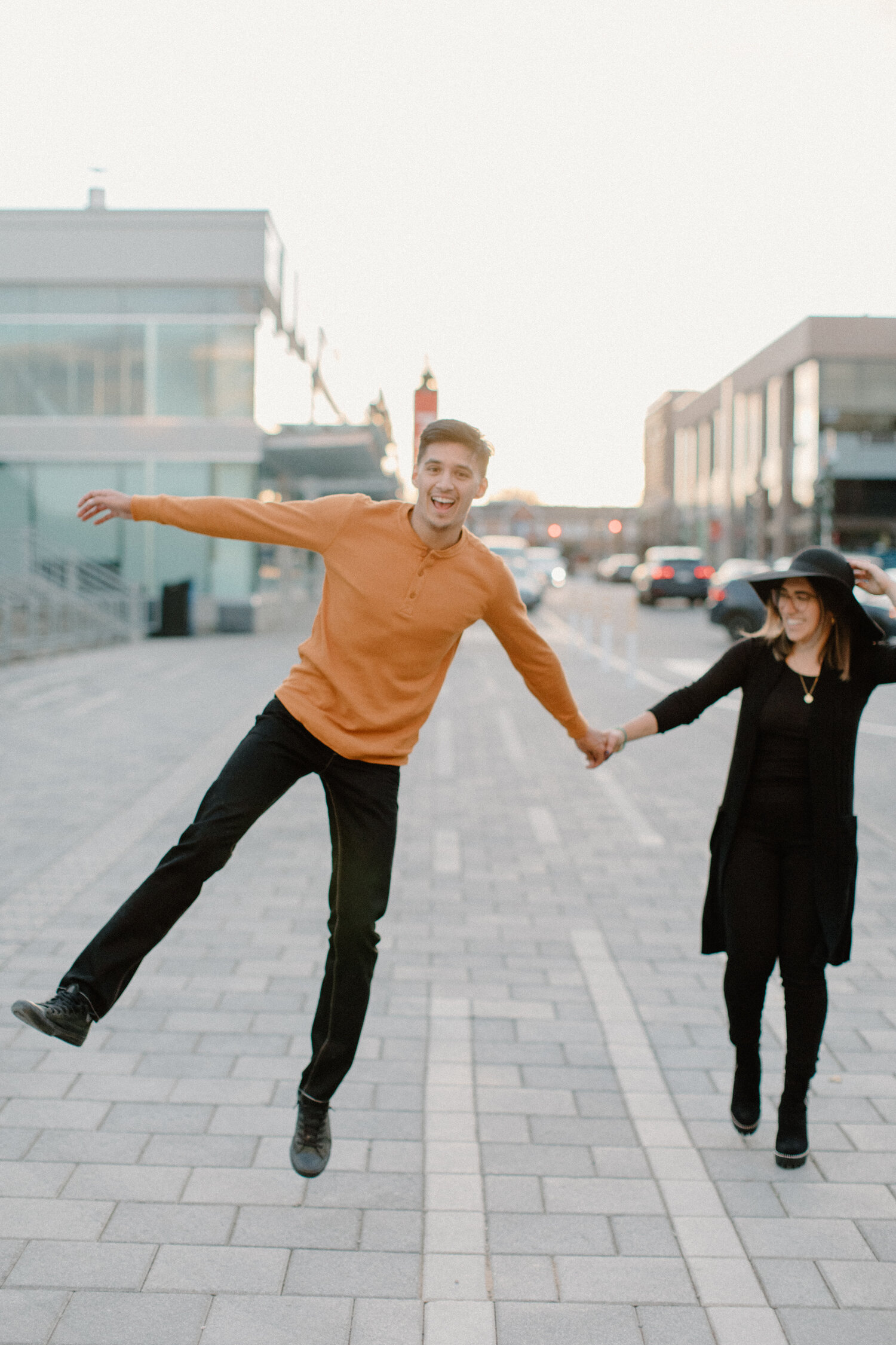  Ottawa, Canada engagement photographer, Chelsea Mason Photography captures this couple skipping happily and playfully down an urban street. engagement photographer ottawa canada black and orange engagement outfit inspiration womens ankle high black 