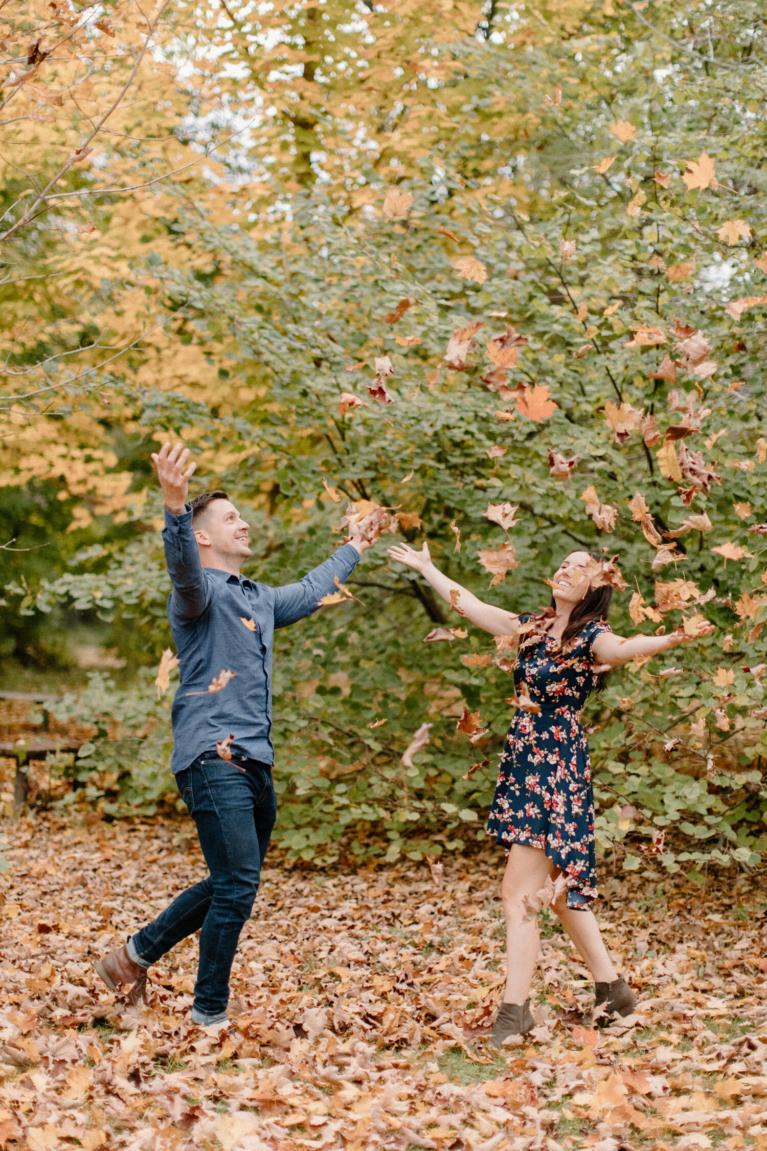  With a wooded forrest blurred in the backdrop, Chelsea Mason Photography captures this man giving his fiance a piggy back ride during their engagement session in Brockville, Ontario. brockville ontario engagement photographer playful couple poses au