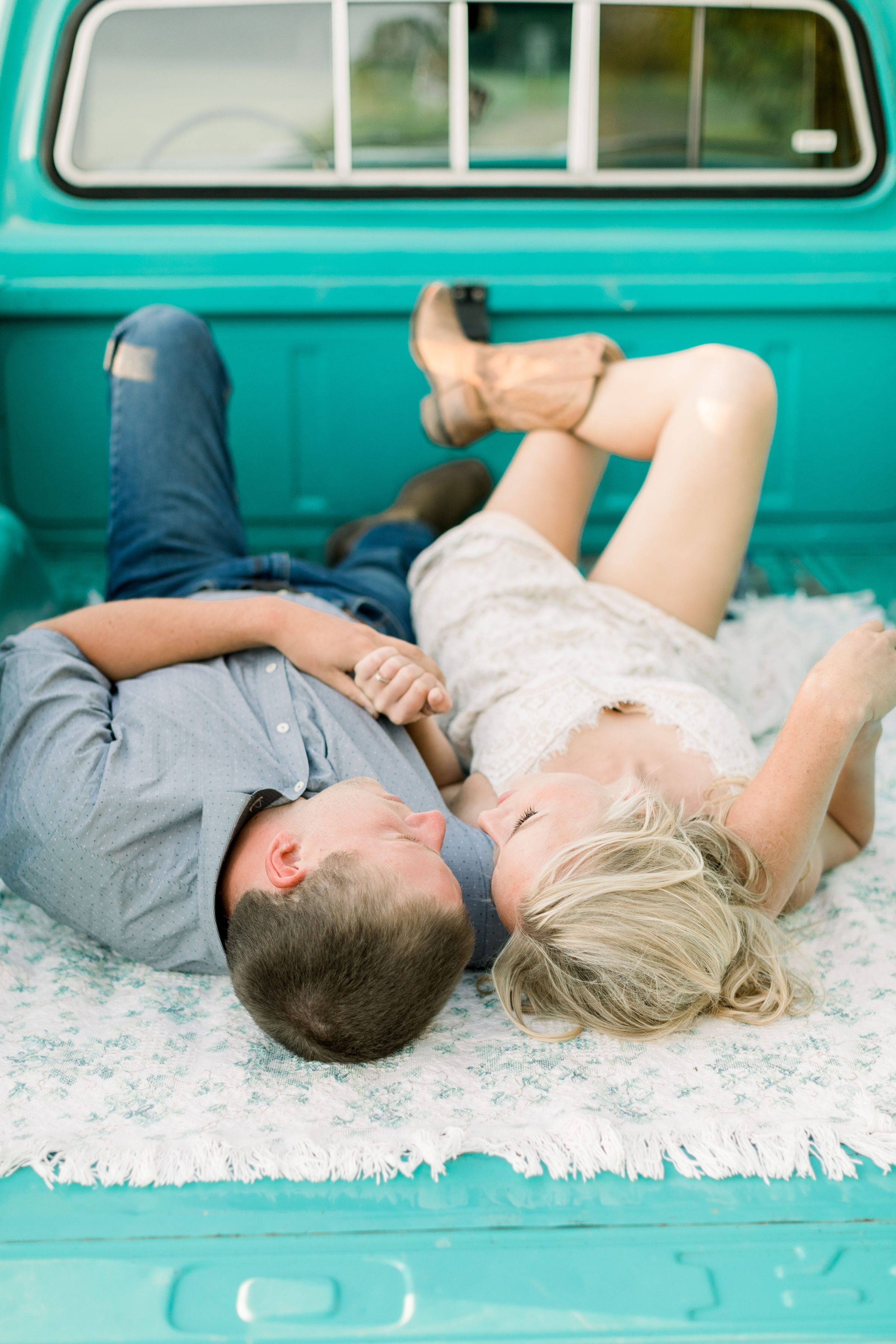  During this southern-styled engagement session in Ottawa, Canada, Chelsea Mason Photography captures this engaged couple laying down in the bed of their Tiffany blue vintage ford pickup truck. vintage ford truck couple holding hands in truck #Chelse
