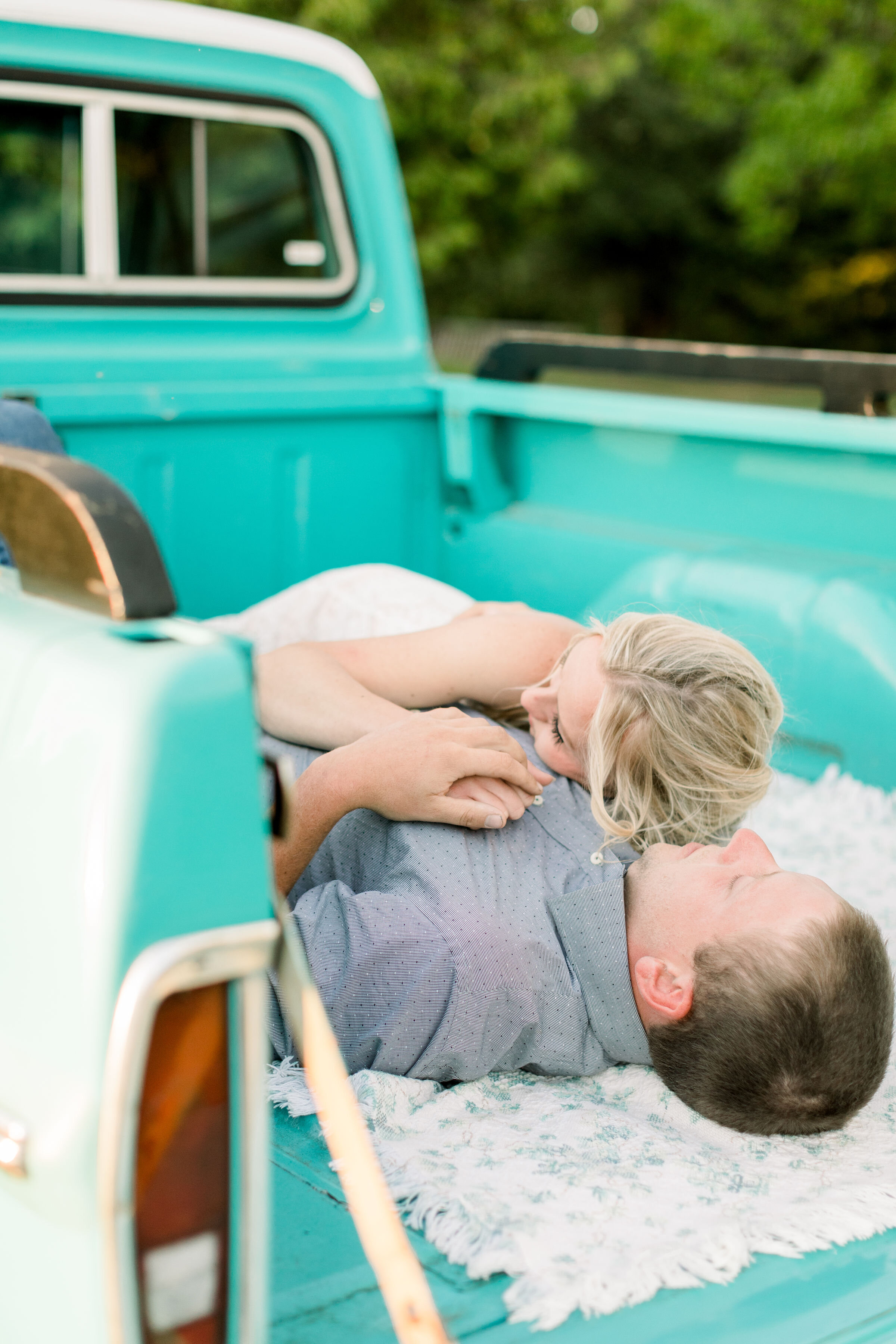  During this southern-styled engagement session in Ottawa, Canada, Chelsea Mason Photography captures this engaged couple laying down in the bed of their Tiffany blue vintage ford pickup truck and cuddling. vintage ford truck engagement prop#ChelseaM