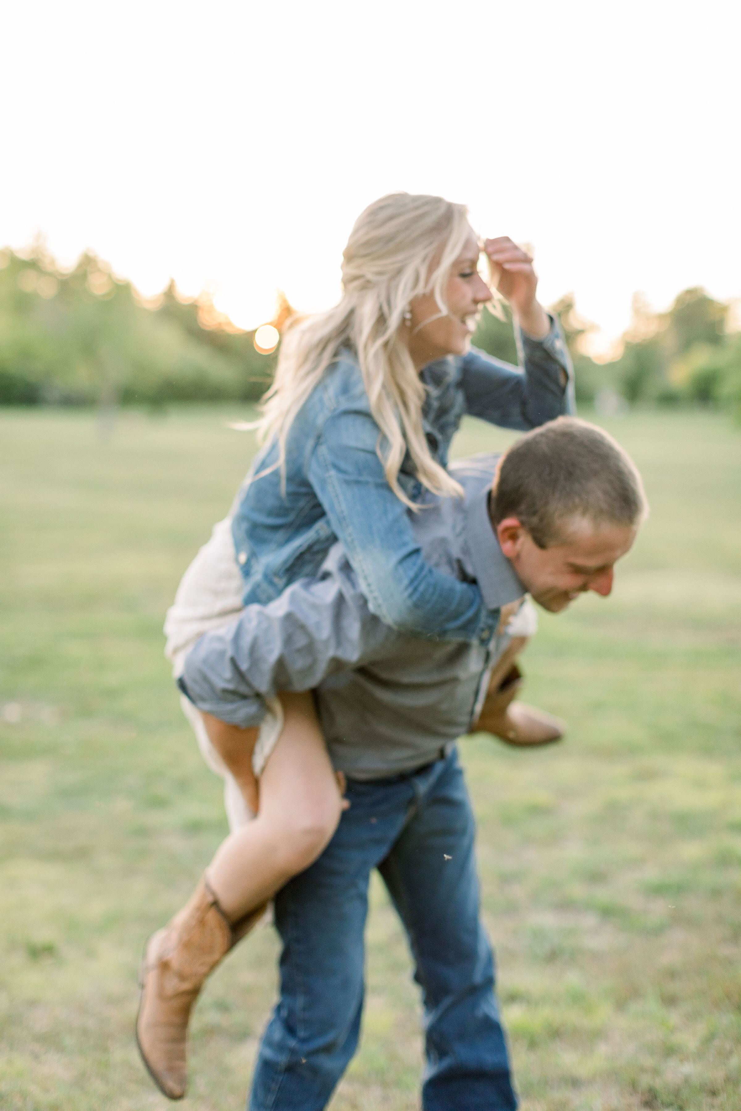  During this playful engagement session in Ottawa, Canada, Chelsea Mason Photography captures this engaged couple giving piggy back rides. laughing piggy back ride women's denim jacket and cowgirl boots #ChelseaMasonPhotography #OttawaOntarioCouplesP