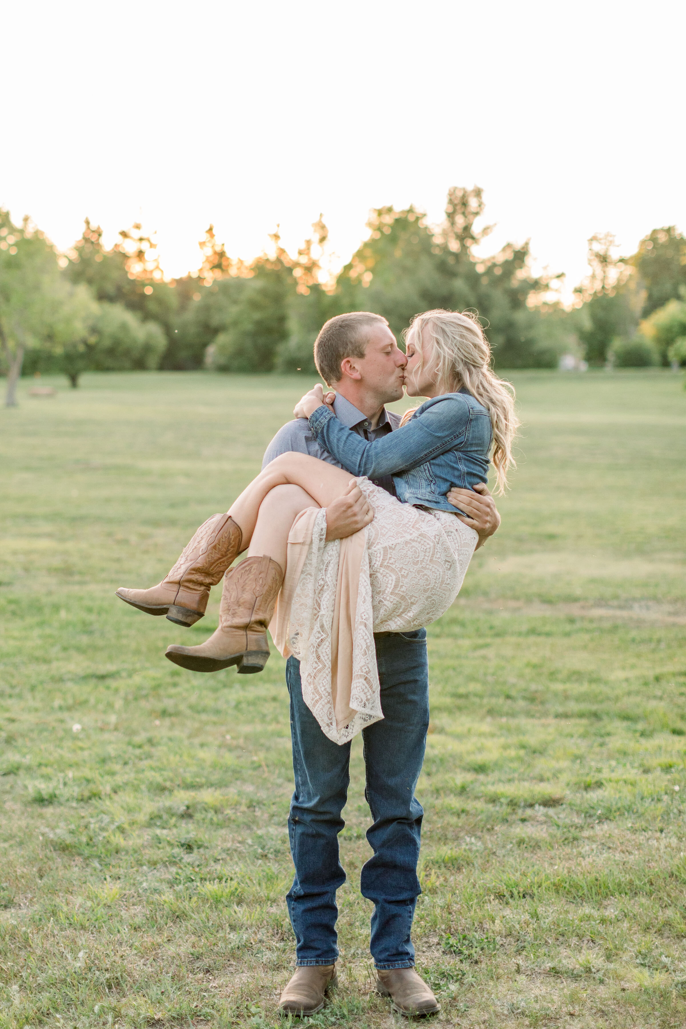  During this romantic southern-styled engagement session in Ottawa, Canada, Chelsea Mason Photography captures this groom carrying his fiancé through a grassy field and kissing her. women's cream lace Dress with cowgirl boots mens work boots #Chelsea