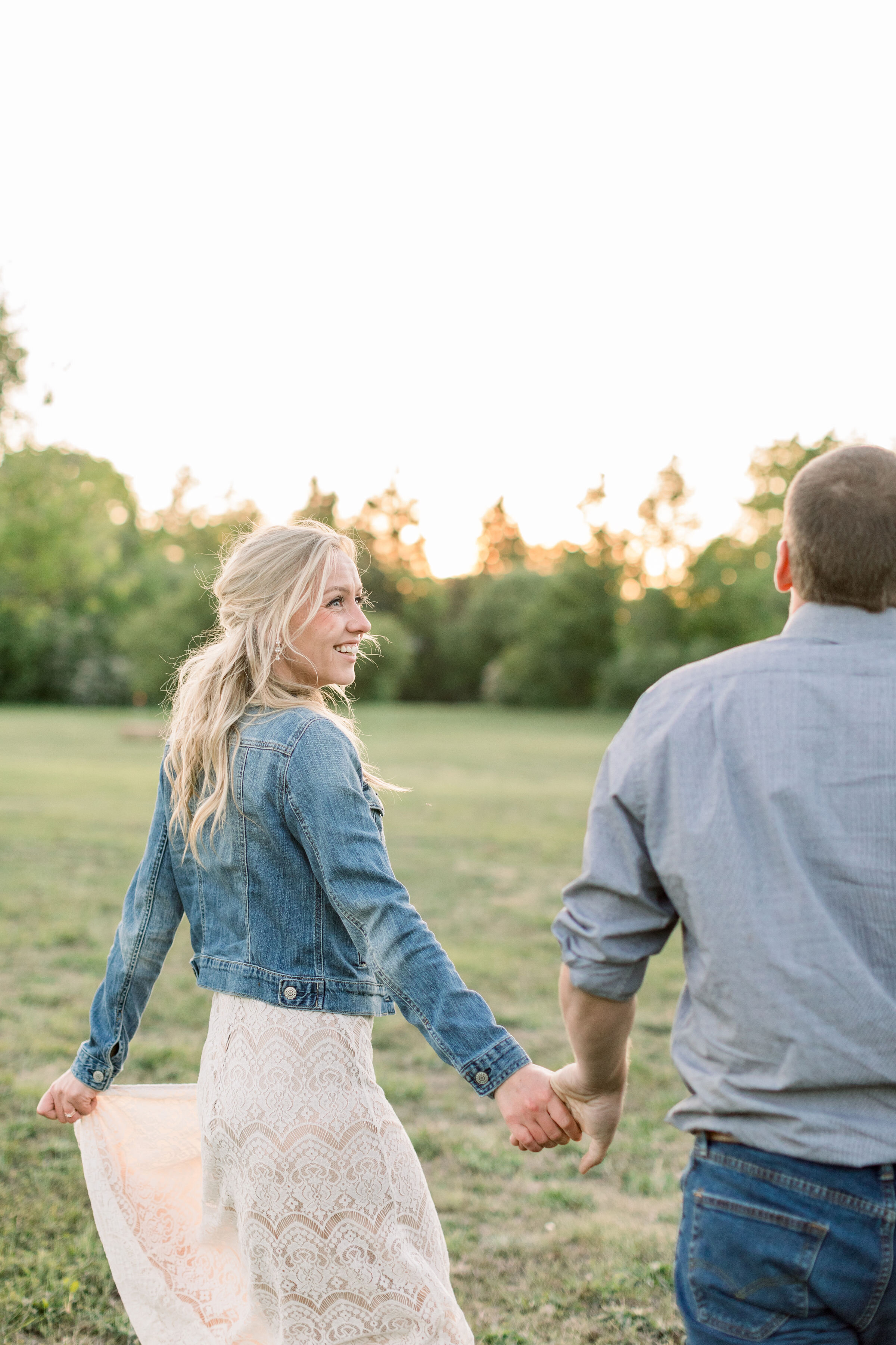  Ottawa, Canada engagement photographer, Chelsea Mason Photography captures this couple running through a grassy field and laughing during their engagement session. engaged couple holding hands and laughing together southern style engagement outfit #
