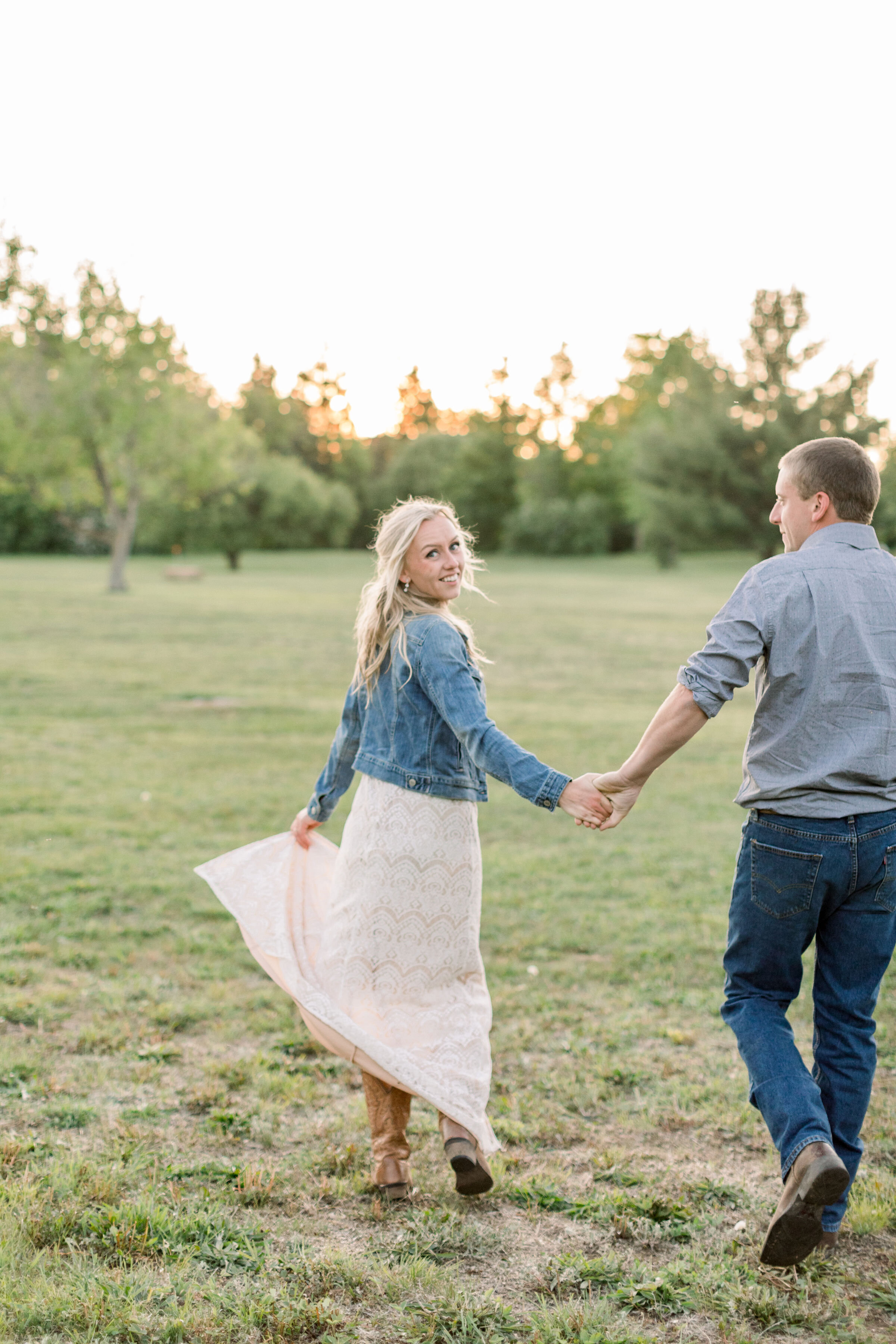  Ottawa, Canada engagement photographer, Chelsea Mason Photography captures a candid moment of this soon-to-be bride looking over her shoulder while holding hands with her fiancé. engagement photos Ottawa photographer women's cowgirl boots #ChelseaMa