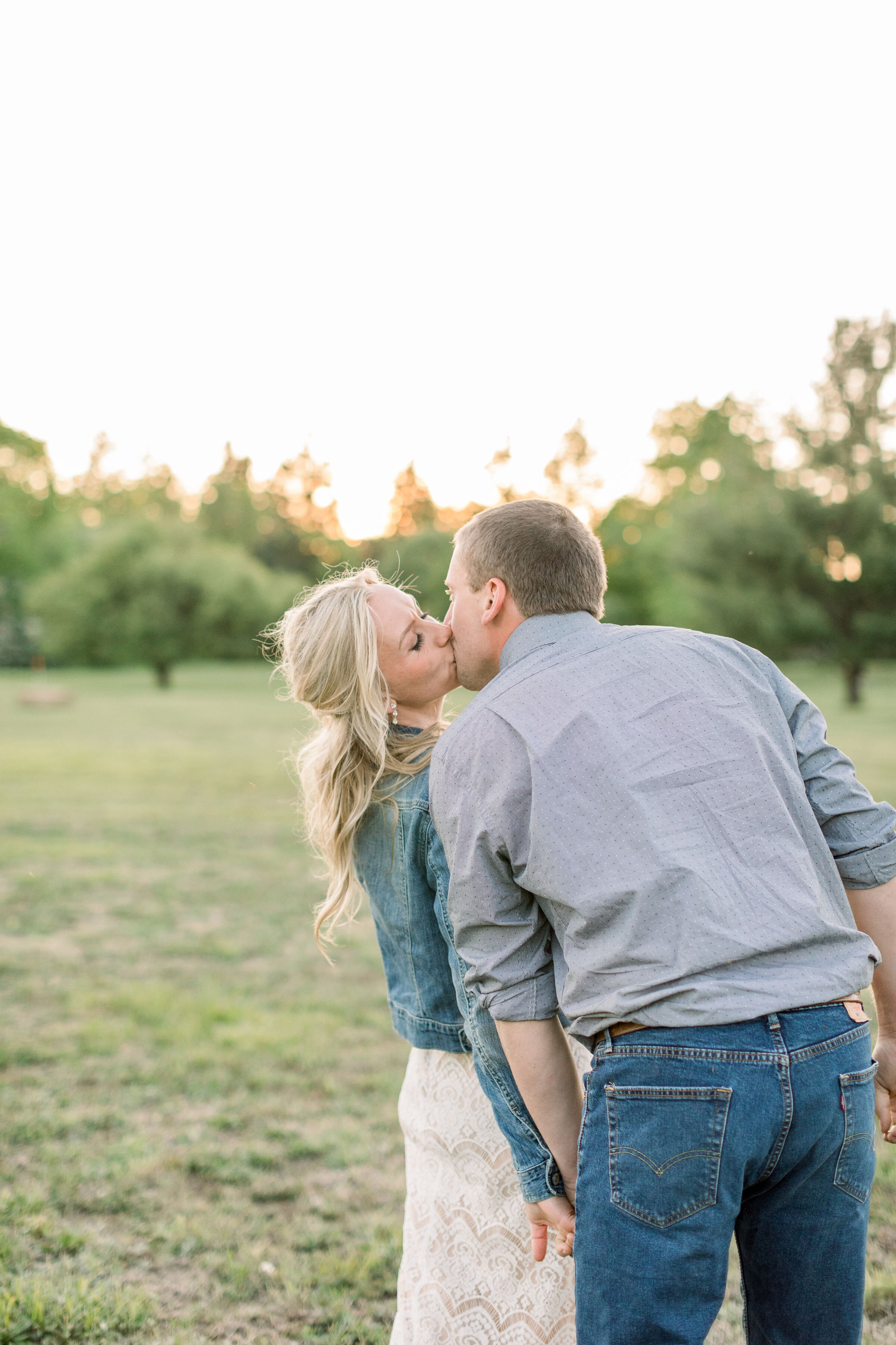  Ottawa, Canada engagement photographer, Chelsea Mason Photography captures this couple walking through a grassy field and stopping to kiss. engaged couple holding hands and walking through field Ottawa canned engagement photographer #ChelseaMasonPho