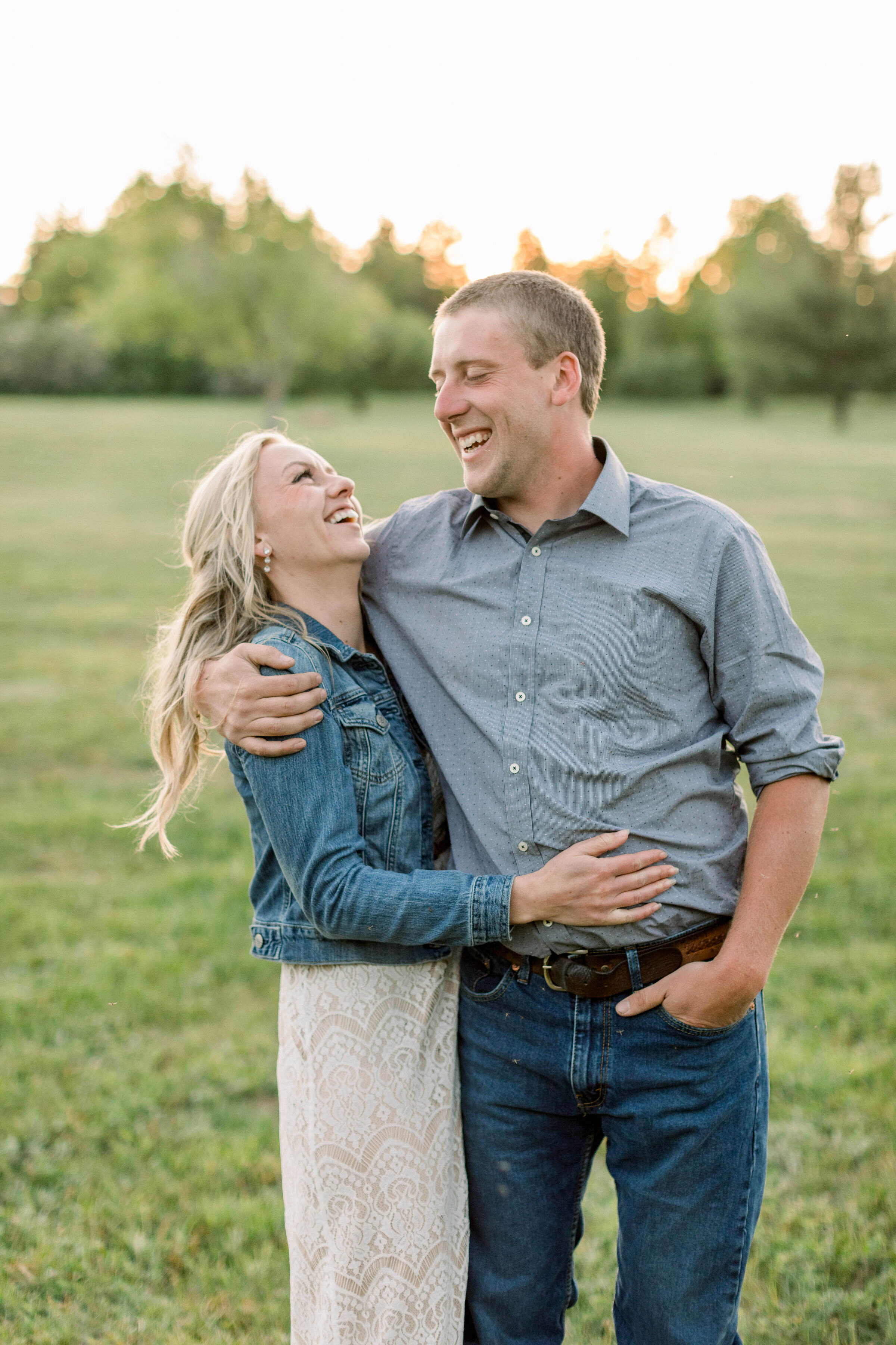  Posed in a grassy field in Ontario, Canada, Chelsea Mason Photography captures this engaged couple wrapping their arms around one another and smiling. women's lace cream maxi Dres with denim jacket mens tucked plaid shirt engagement   outfit  #Chels