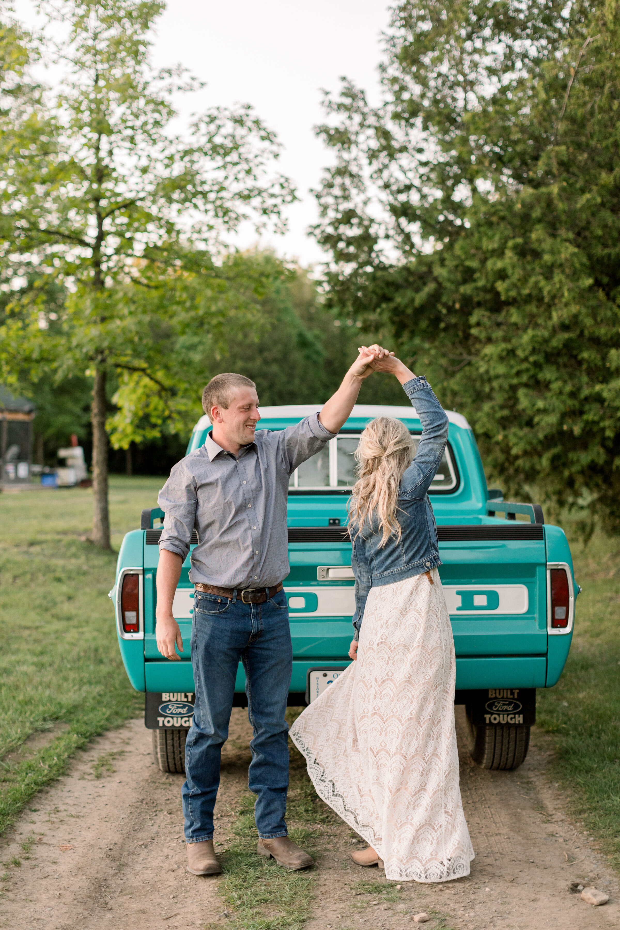  Posed behind a vintage Ford pickup truck, Ottawa, Ontario couples photographer, Chelsea Mason Photography captures this engaged couple twirling playfully. Tiffany blue ford pickup truck southern styled engagement outfits women's cowgirl boots #Chels