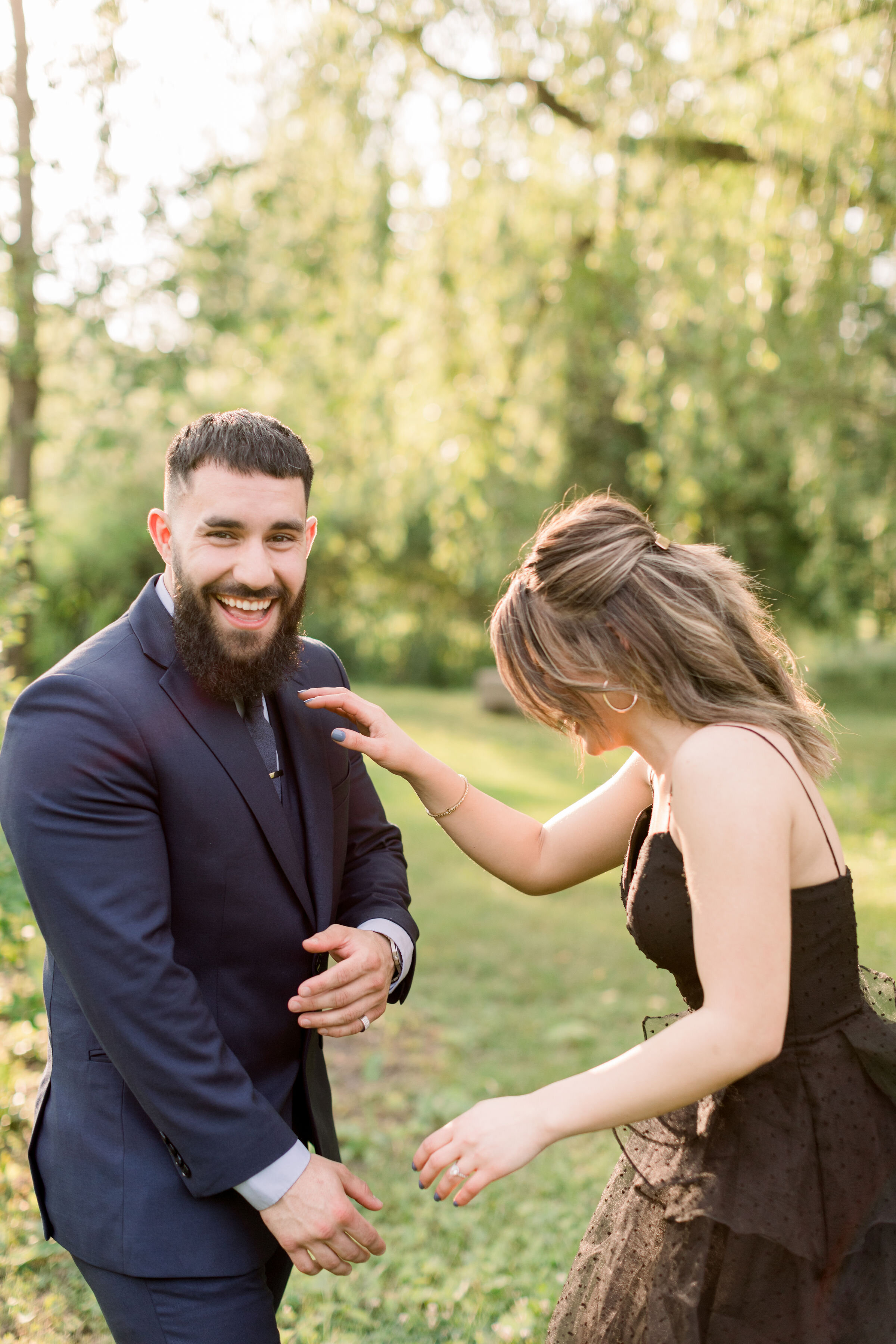  During this playful engagement session in Ottawa, Ontario, Chelsea Mason Photography captures this couple laughing with their heads back. laughing engagement photos formal engagement outfits women's black spaghetti strapped tea length dress with hee