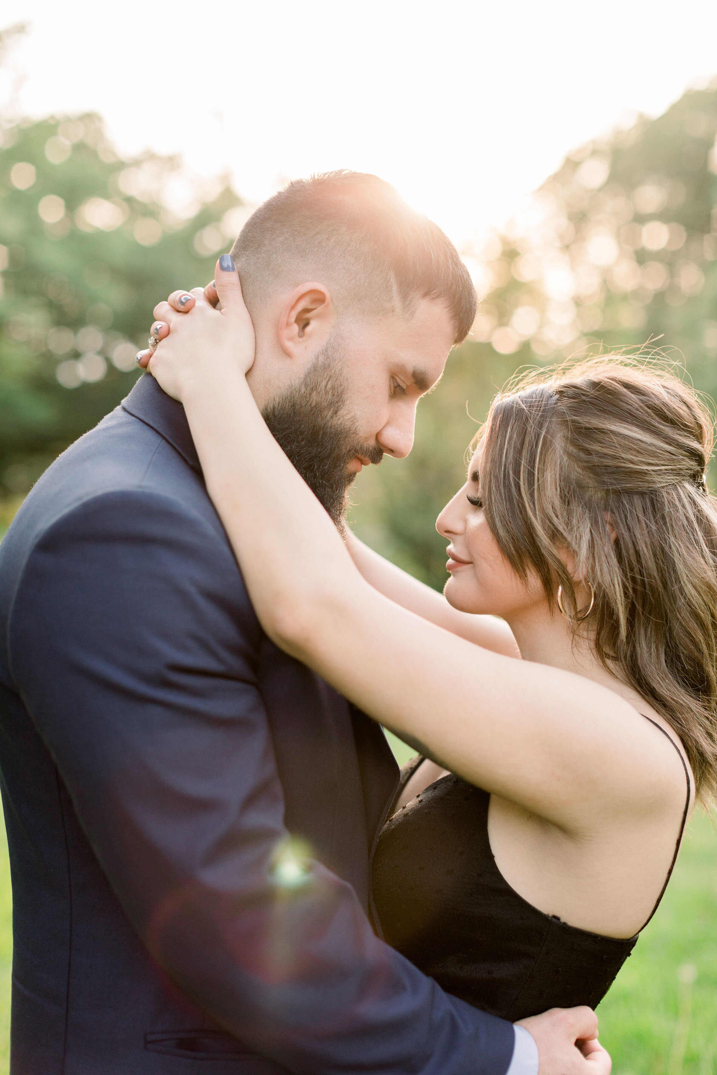  During this park engagement session in Ottawa, Canada, Chelsea Mason photography captures this soon-to-be groom embracing his fiancé tenderly while gazing down at her.  groom embracing fiancé woman's eyes clothes tender romantic couples poses Ottawa