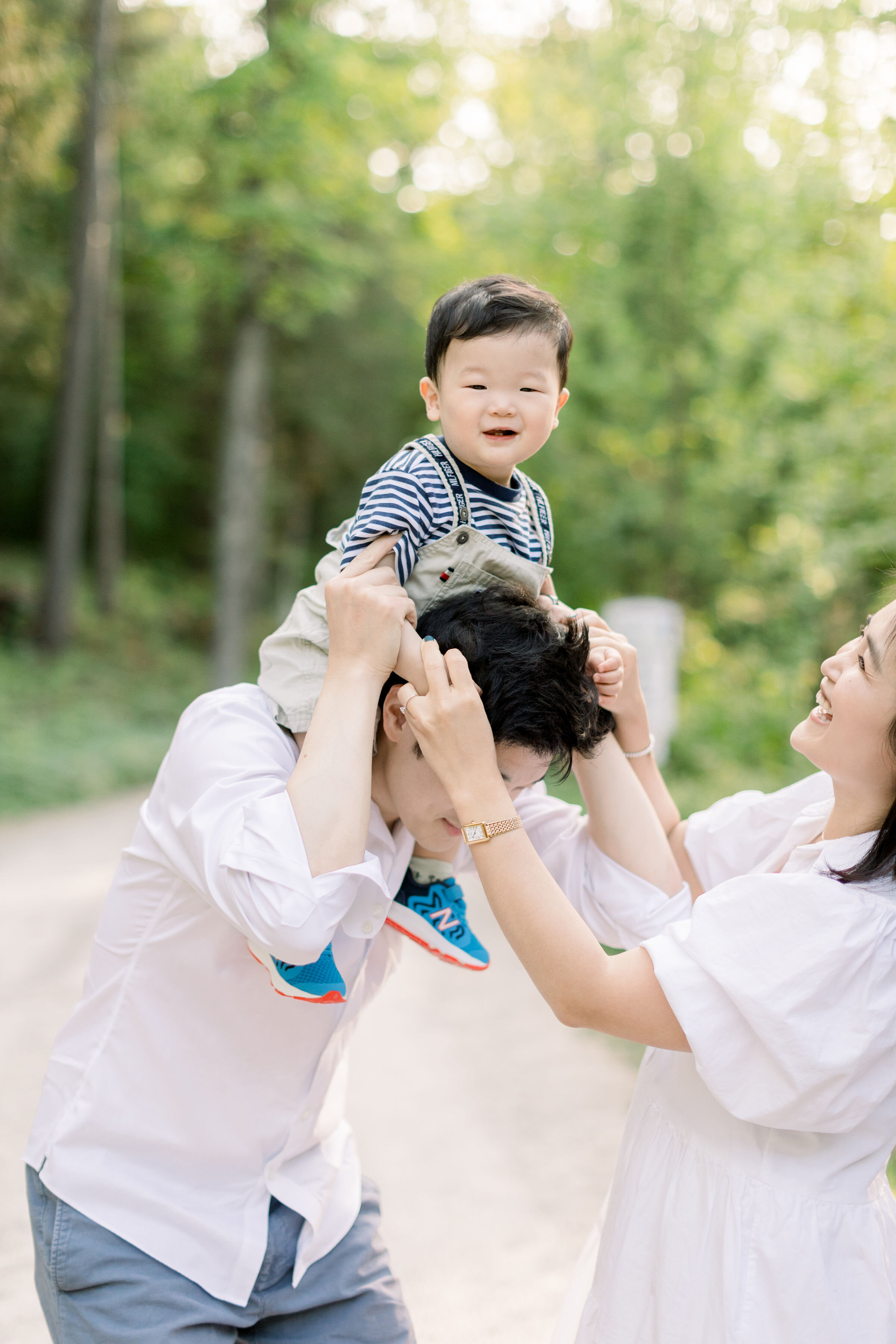  Ottawa, Ontario family photographer, Chelsea Mason photography captures this toddler boy playfully riding his father's shoulders during this family session. Ottawa Ontario family photographer toddler boy on father's shoulders mother laughing #Almont