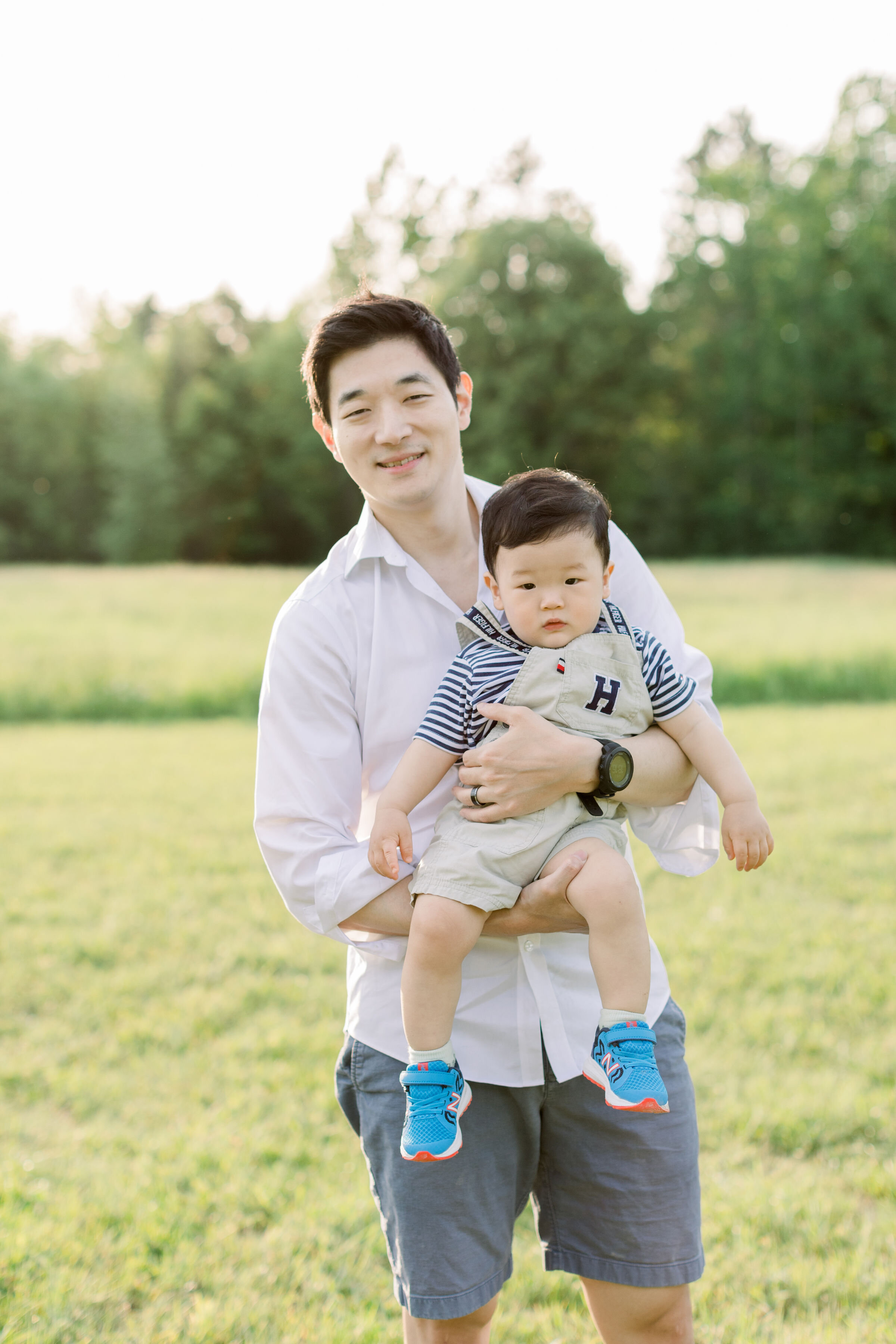  Ottawa, Ontario family photographer, Chelsea Mason Photography captures this father holding his toddler son during this family session. Ottawa Ontario Canada family photographer white family photo outfits toddler boy overalls with striped shirt #Che