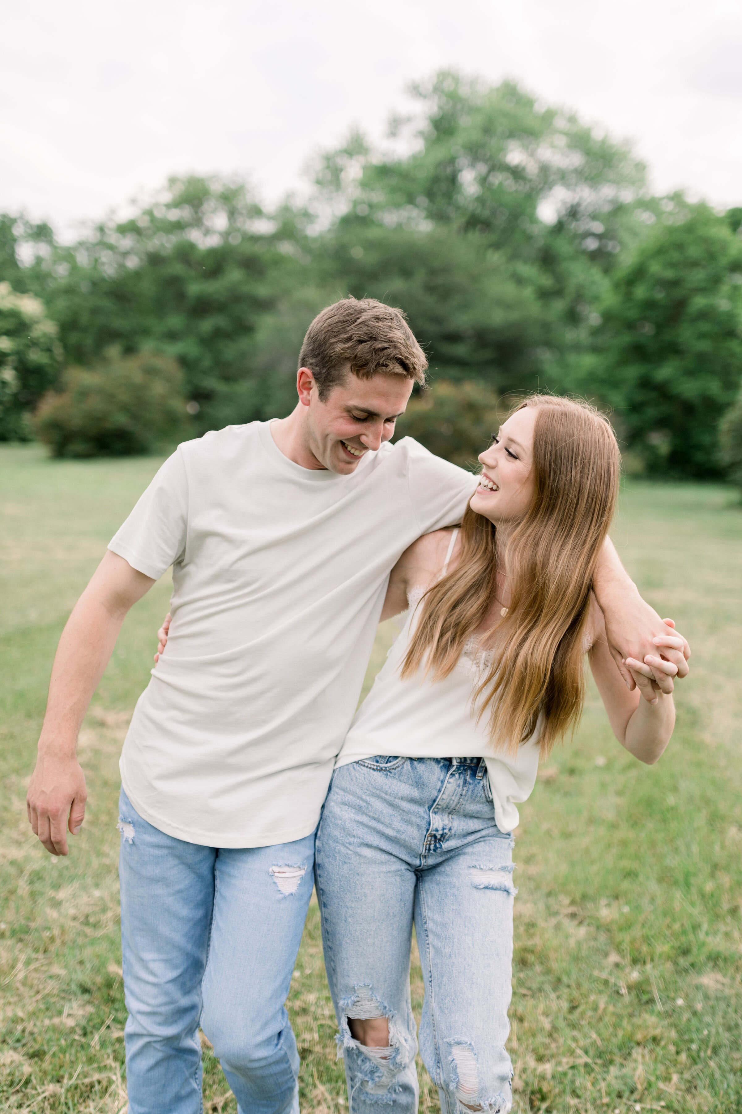  During this playful engagement session with Chelsea Mason Photography in Ottawa, Ontario, this couple jokingly wraps arms around one another and walks through a grassy field. playful engagement session poses Ottawa engagment photographer #ChelseaMas