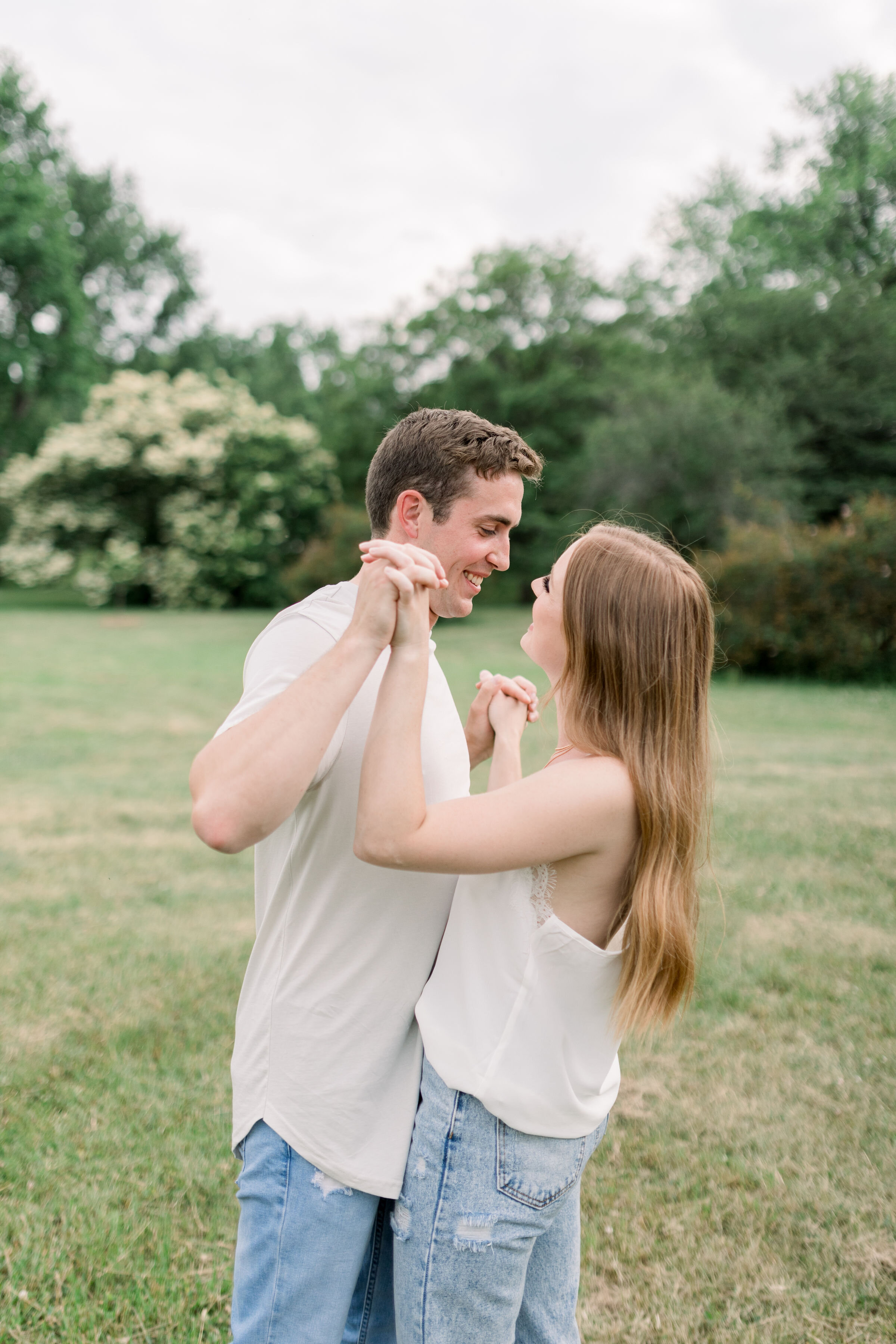  Ottawa, Ontario photographer, Chelsea Mason Photography captures a candid moment between this couple during their engagement session as they link fingers together. neutral colored white denim engagement outfits casual engagement outfits Ontario Otta