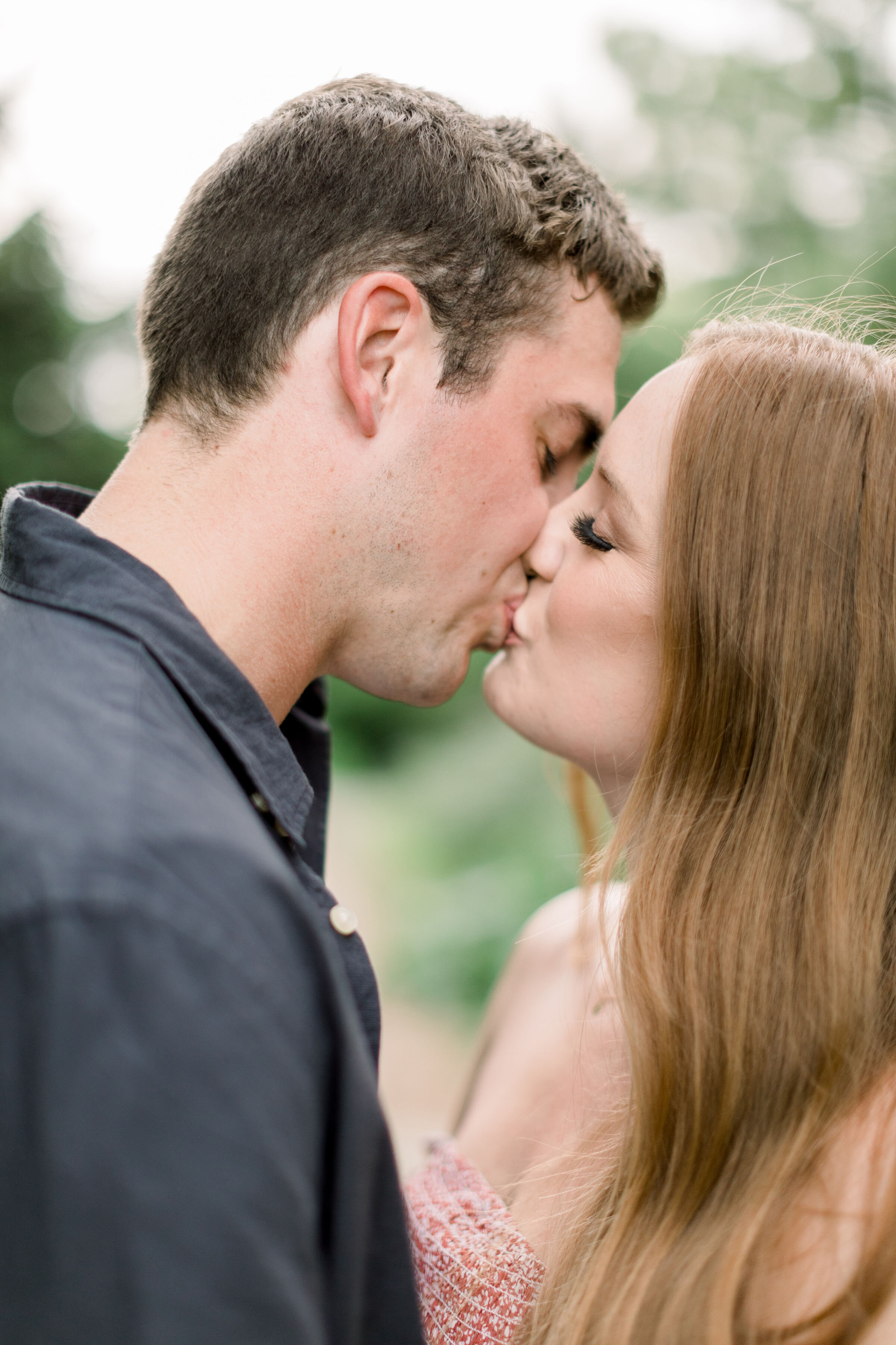  Chelsea Mason Photography captures a tender moment between this engaged couple as they kiss romantically in a wooded pathway in Arboretum, Ottawa. arboretum Ottawa photographer formal engagement outfits up close kissing photo women's auburn hair  #C