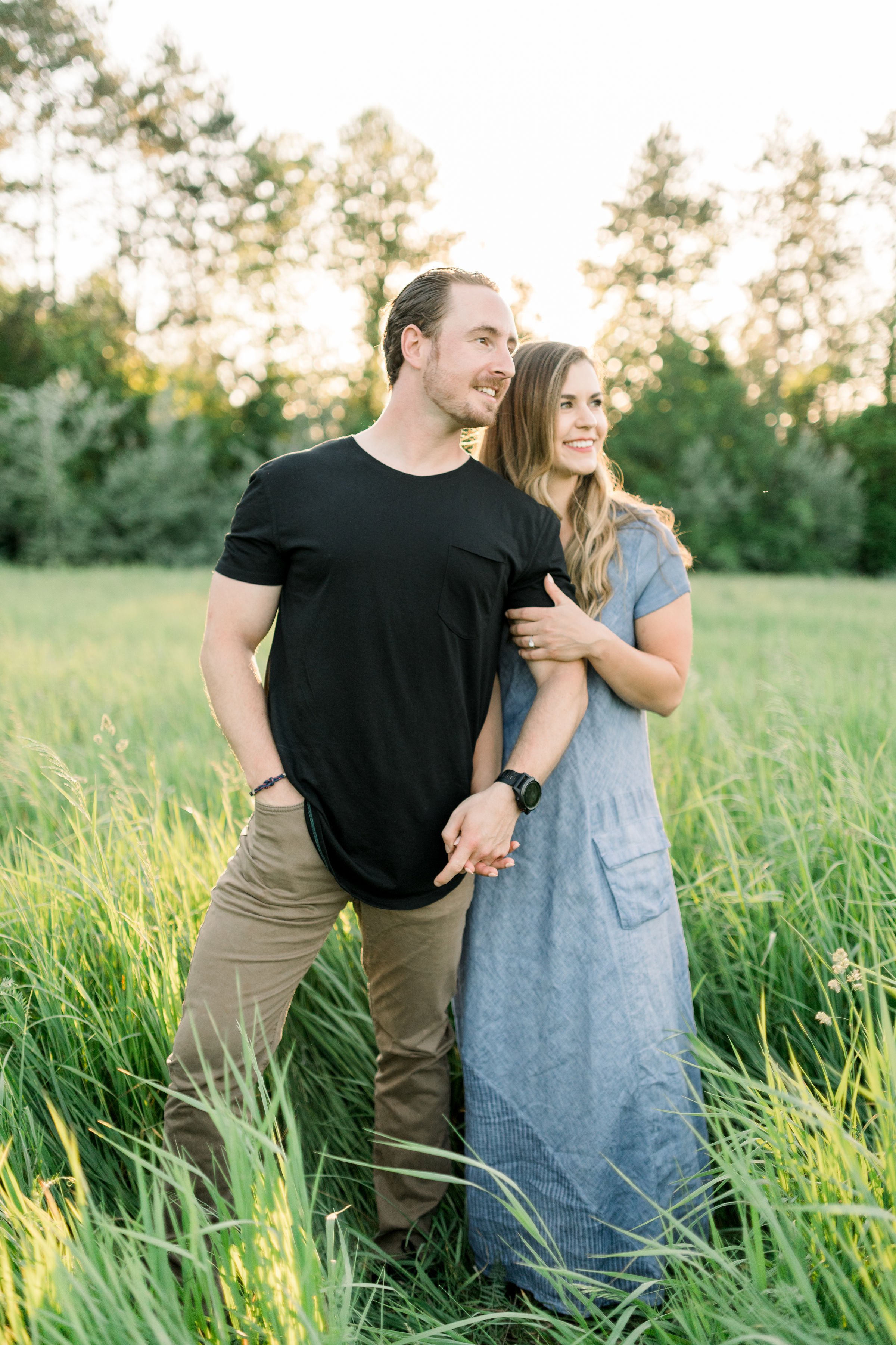  Chelsea Mason Photography captures a couple snuggling and looking off in the distance in a field. sunset engagements Canada photog #chelseamasonphotography #chelseamasonengagements #Ottawaengagments #Almonteengagementphotographer #outdoorengagments 