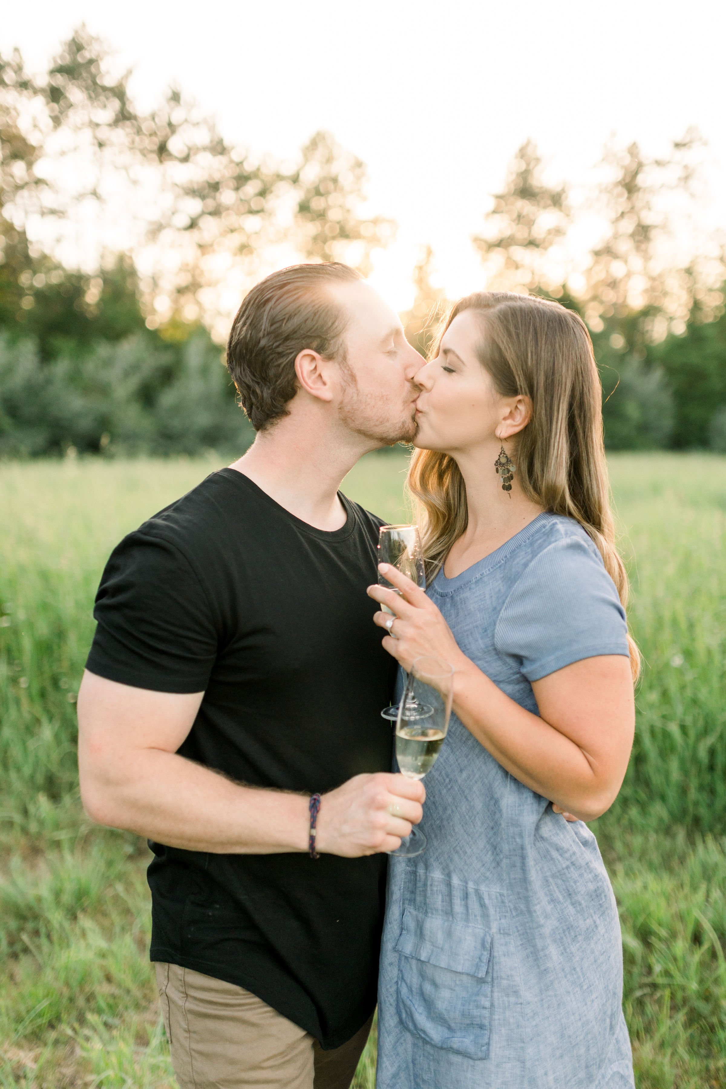  While kissing fiances hold their celebratory champagne glasses by Chelsea Mason Photography. Almonte photography champaign #chelseamasonphotography #chelseamasonengagements #Ottawaengagments #Almonteengagementphotographer #outdoorengagments 