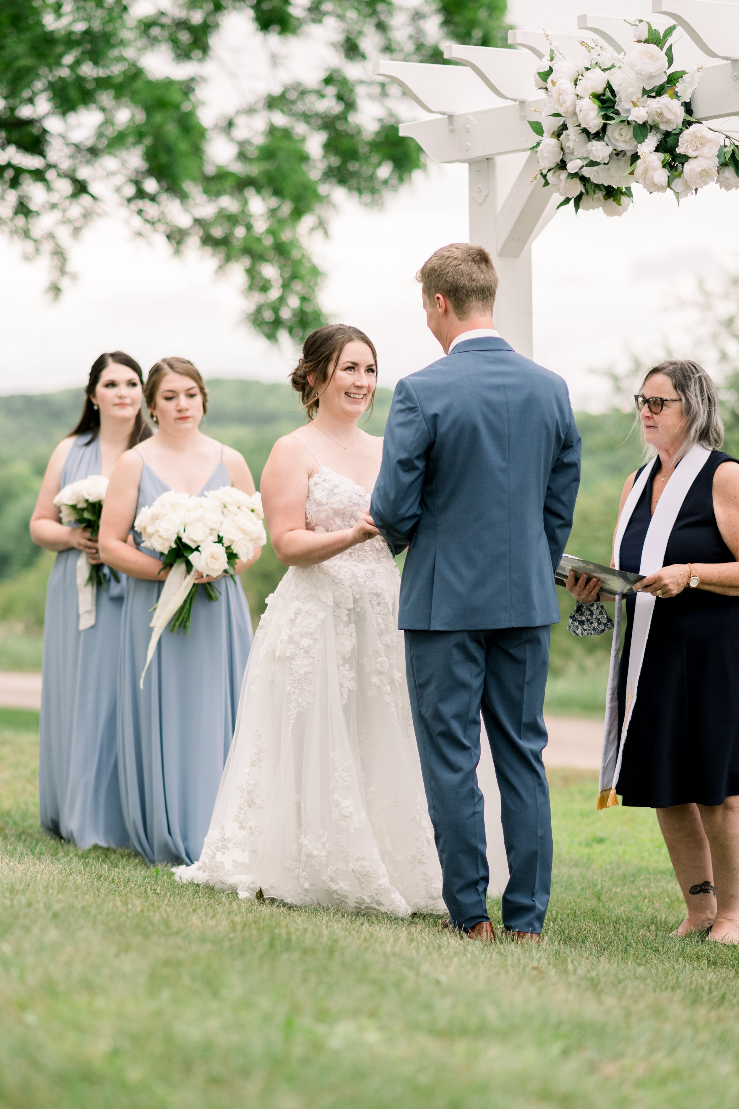  A bride smiles glowingly as the groom holds her hand at the altar by Chelsea Mason Photography. bride and groom at altar summer wedding #chelseamasonphotography #chelseamasonweddings #Ontarioweddings #Boulterweddingphotographer #laceweddinggown 