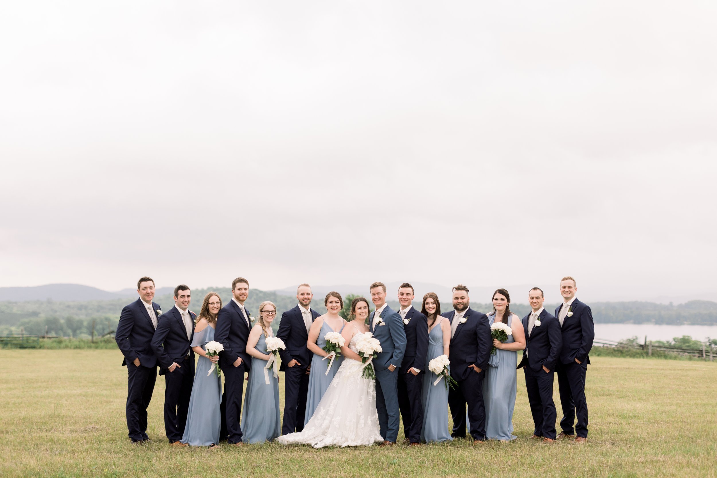  Wedding party portrait in front of a lake in Boulter, Ontario by Chelsea Mason Photography. outside wedding party portraits Ontario #chelseamasonphotography #chelseamasonweddings #Ontarioweddings #Boulterweddingphotographer #laceweddinggown 