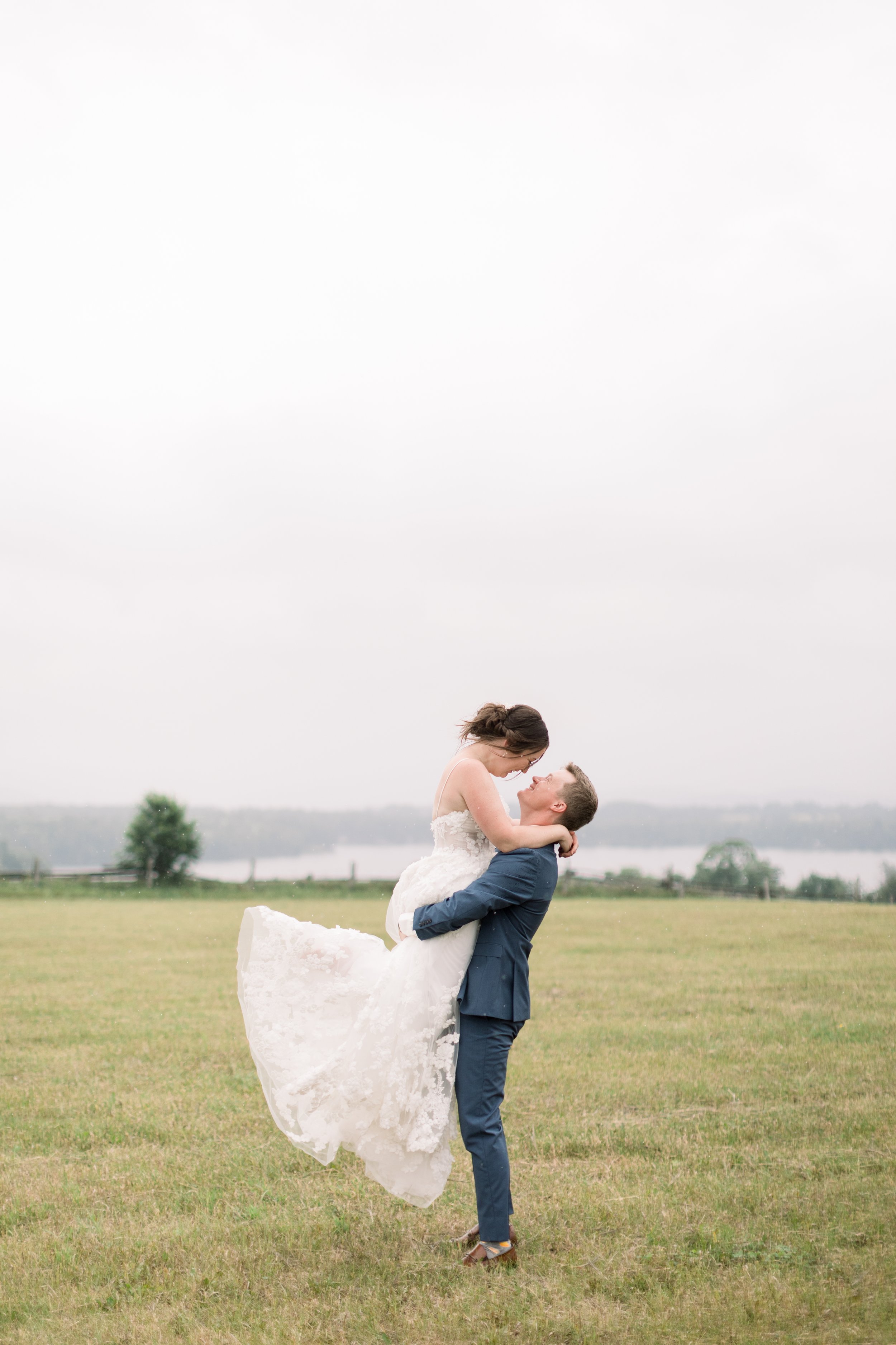  Groom holds his bride up in the air and kisses her by Chelsea Mason Photography. foot pop wedding kiss summer wedding in Canada stormy wed #chelseamasonphotography #chelseamasonweddings #Ontarioweddings #Boulterweddingphotographer #laceweddinggown 