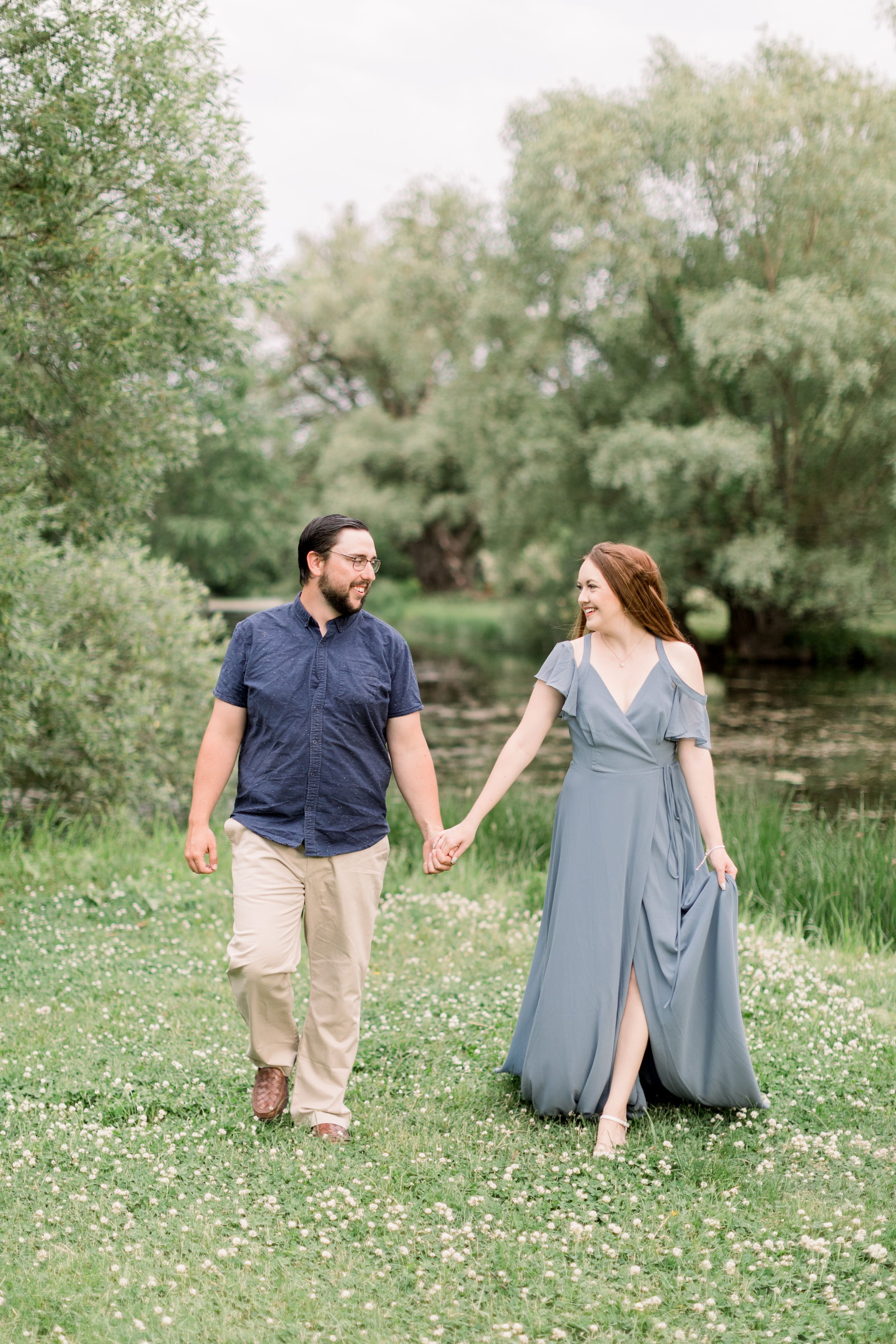  Looking lovingly at one another a newly engaged couple holds hands next to a swamp with Chelsea Mason Photography. swamp location engagements #chelseamasonphotography #chelseamasonengagements #Ottawaengagements #DominonArboretum #Ottawaphotographers