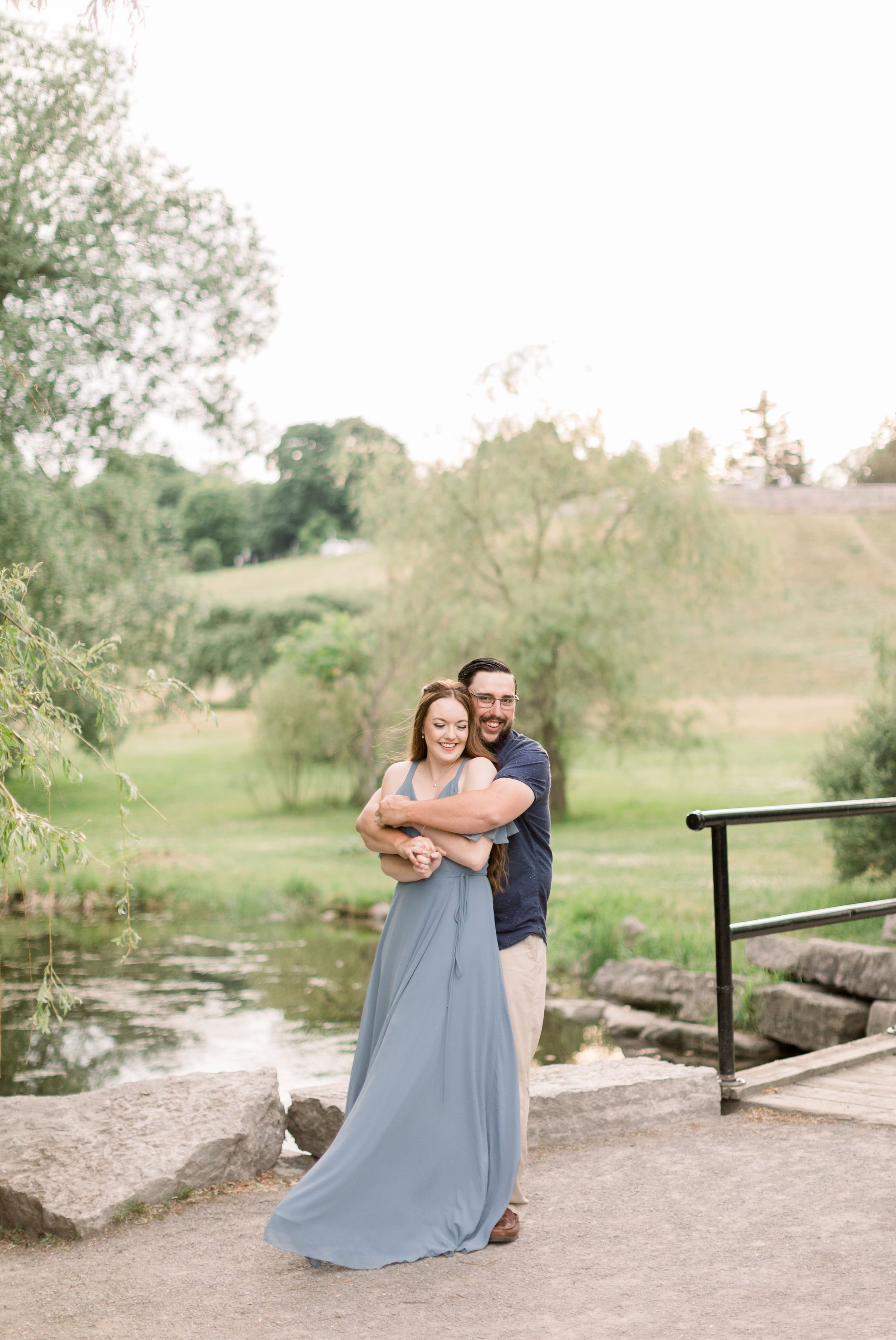  Fiances hold his soon-to-be bride from behind in a big hug by Chelsea Mason Photography an Ottawa engagement photographer. engagement pond #chelseamasonphotography #chelseamasonengagements #Ottawaengagements #DominonArboretum #Ottawaphotographers&nb