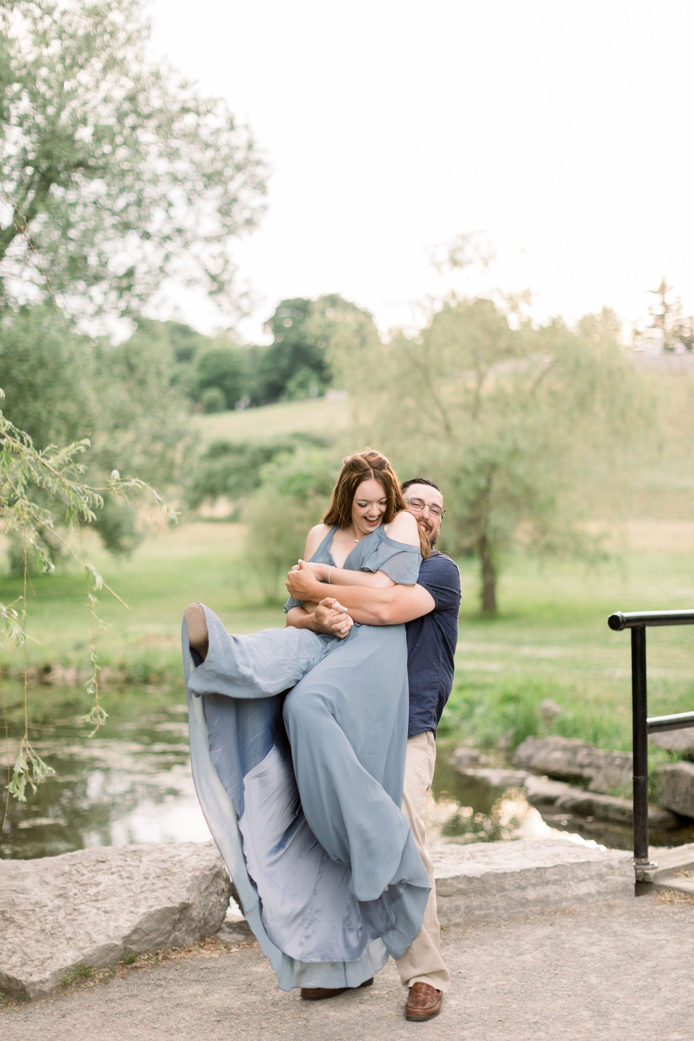  Ottawa engagement photographer Chelsea Mason Photography captures a woman being lifted up by her fiance as she laughs. candid engagement pics #chelseamasonphotography #chelseamasonengagements #Ottawaengagements #DominonArboretum #Ottawaphotographers