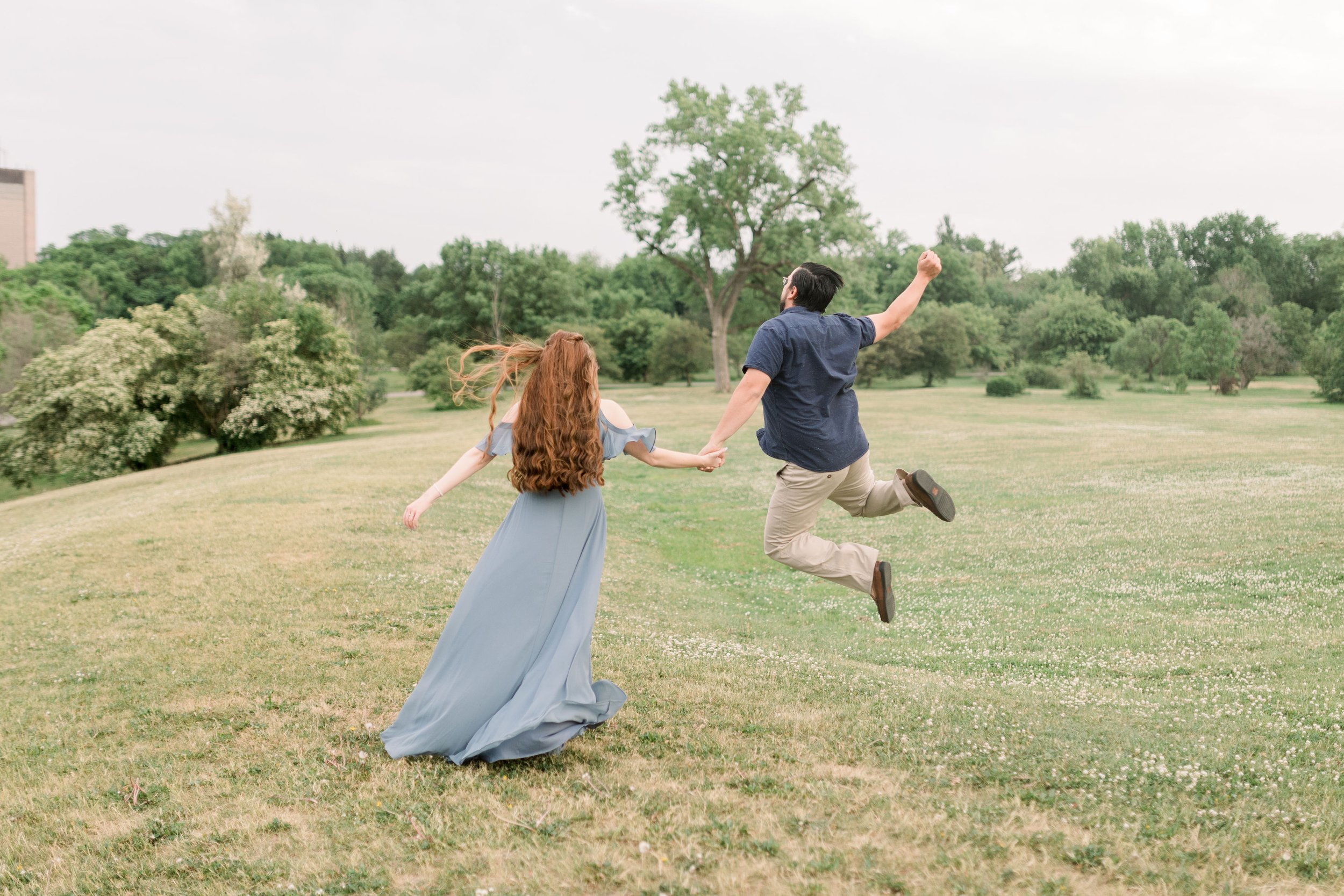  During an engagement session in Ottawa, a man does a heel click while holding his fiance's hand by Chelsea Mason Photography. heel click #chelseamasonphotography #chelseamasonengagements #Ottawaengagements #DominonArboretum #Ottawaphotographers&nbsp