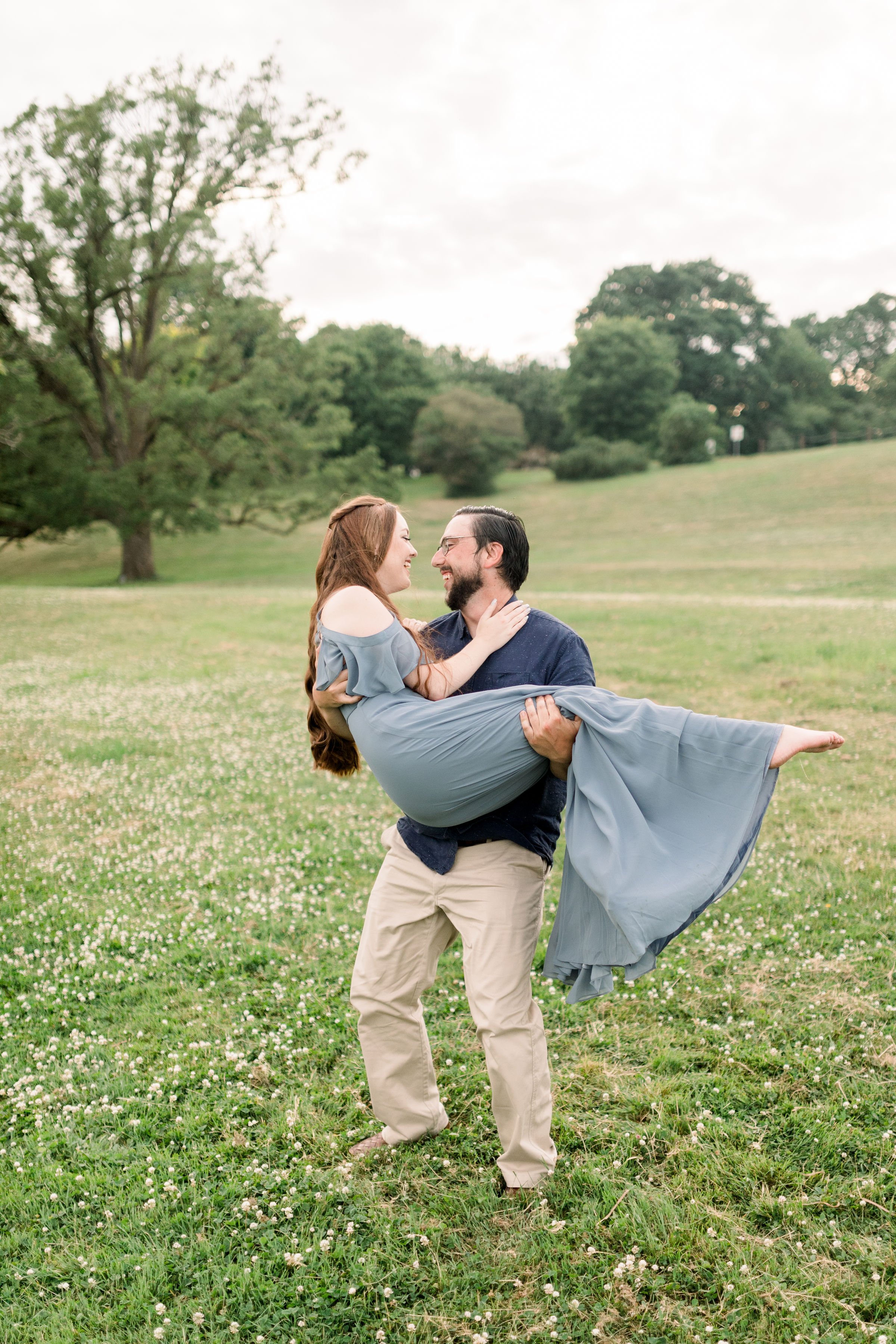  Fiance holds his future wife in his arms and twirls her around by Chelsea Mason Photography. blue off the shoulder dress tan pants #chelseamasonphotography #chelseamasonengagements #Ottawaengagements #DominonArboretum #Ottawaphotographers&nbsp; 