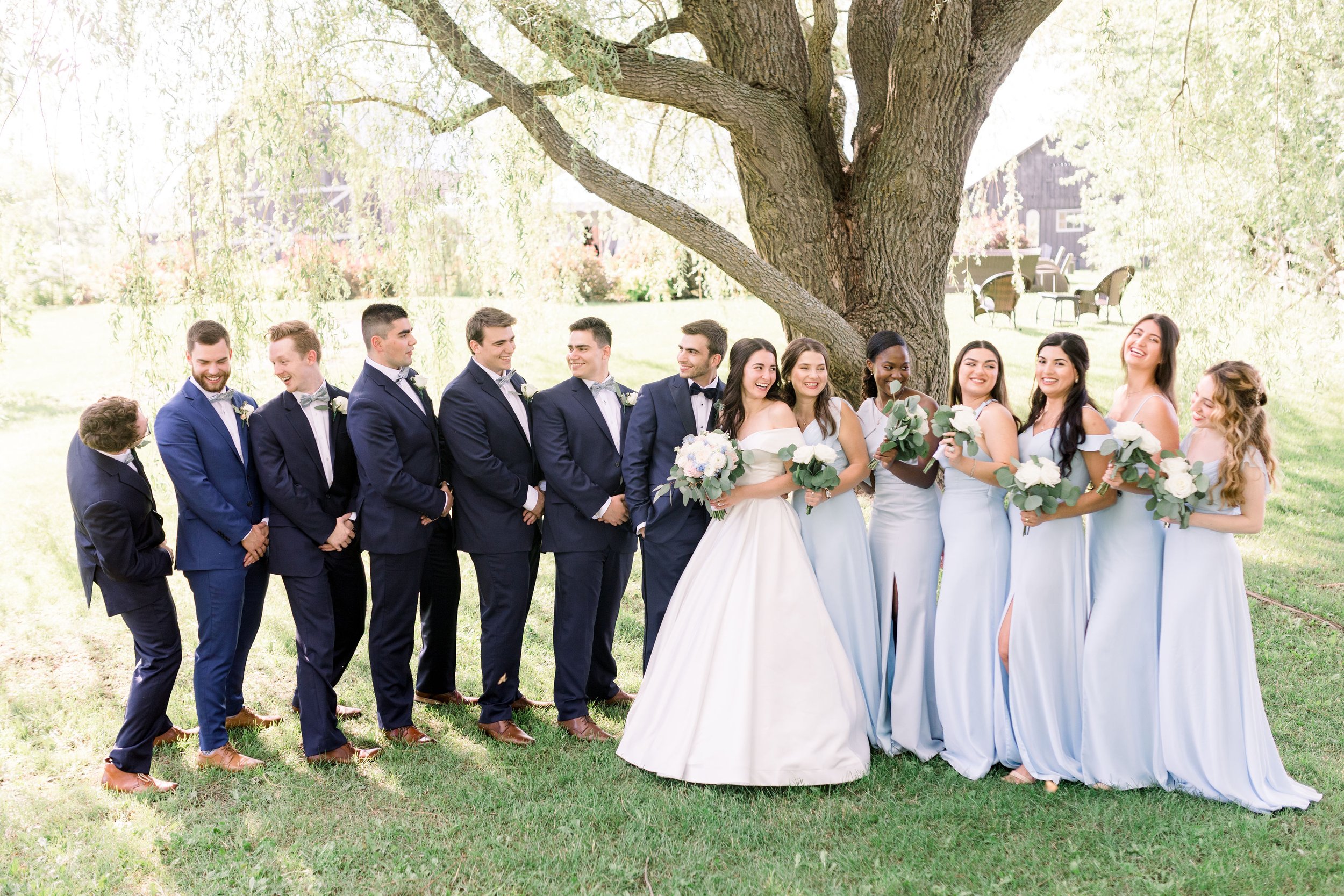  Bride and groom laugh with their groomsmen and bridesmaids by Chelsea Mason Photography. Almonte wedding photographers bridal party #Chelseamasonphotography #Chelseamasonweddings #Onatarioweddings #EvermoreweddingsAlmonte #Ontarioweddingphotographer