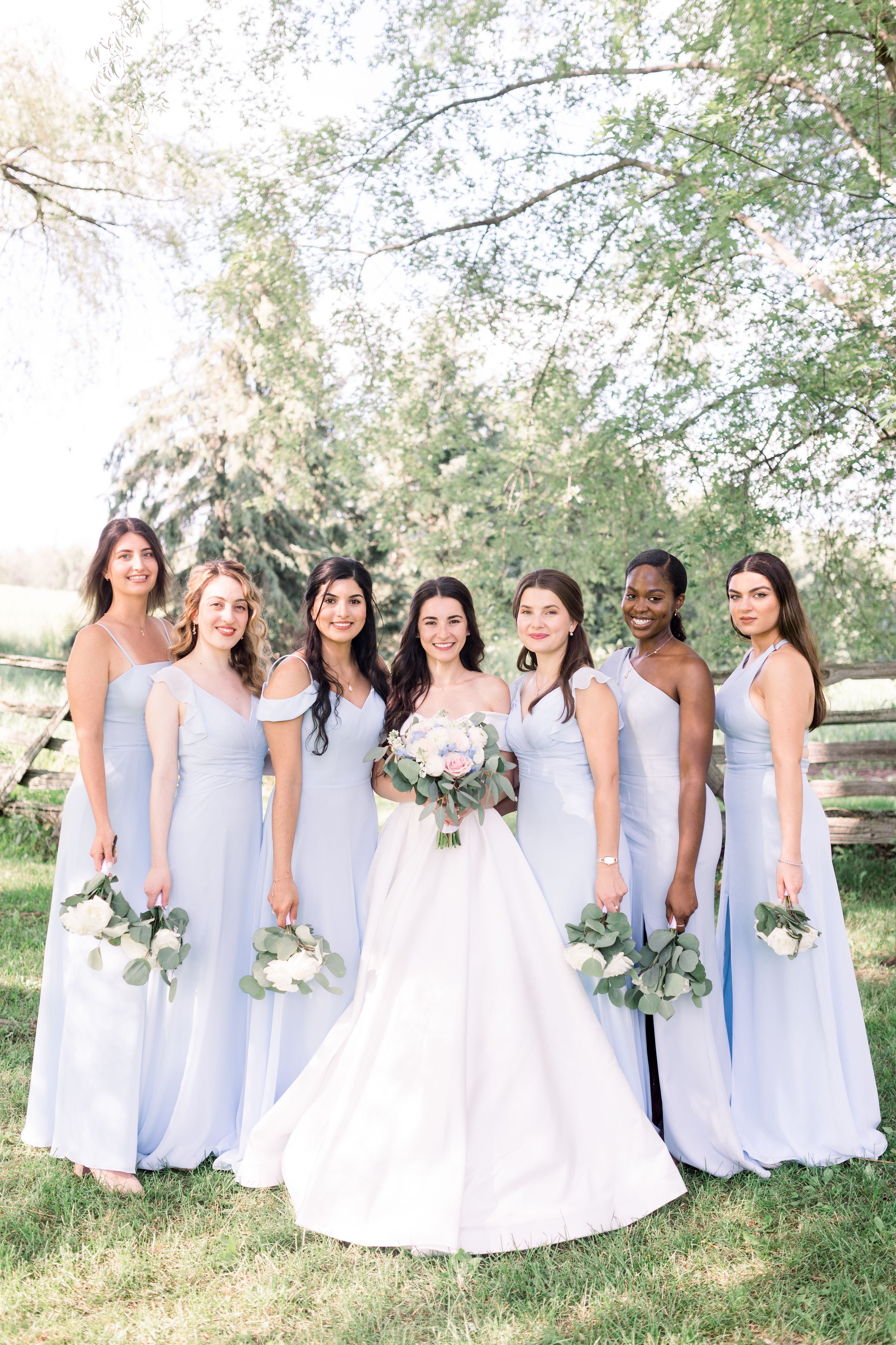  Bridesmaids in light blue dresses pose next to the bride in Almonte by Chelsea Mason Photography. bridesmaids in blue #Chelseamasonphotography #Chelseamasonweddings #Onatarioweddings #EvermoreweddingsAlmonte #Ontarioweddingphotographers 