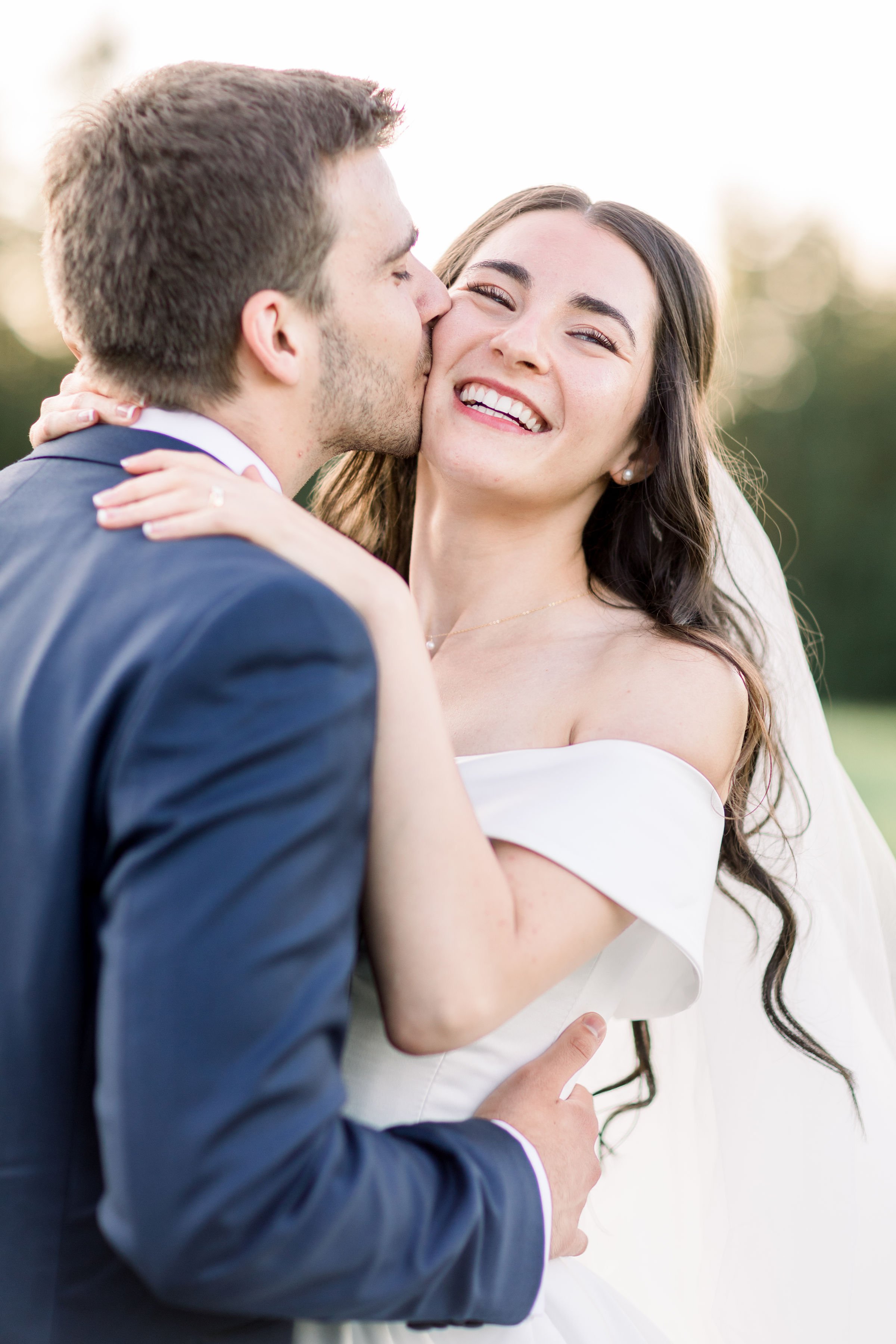  The bride smiles with pure joy on her wedding day as the groom kisses her by Chelsea Mason Photography. bride pure joy smile #Chelseamasonphotography #Chelseamasonweddings #Onatarioweddings #EvermoreweddingsAlmonte #Ontarioweddingphotographers 