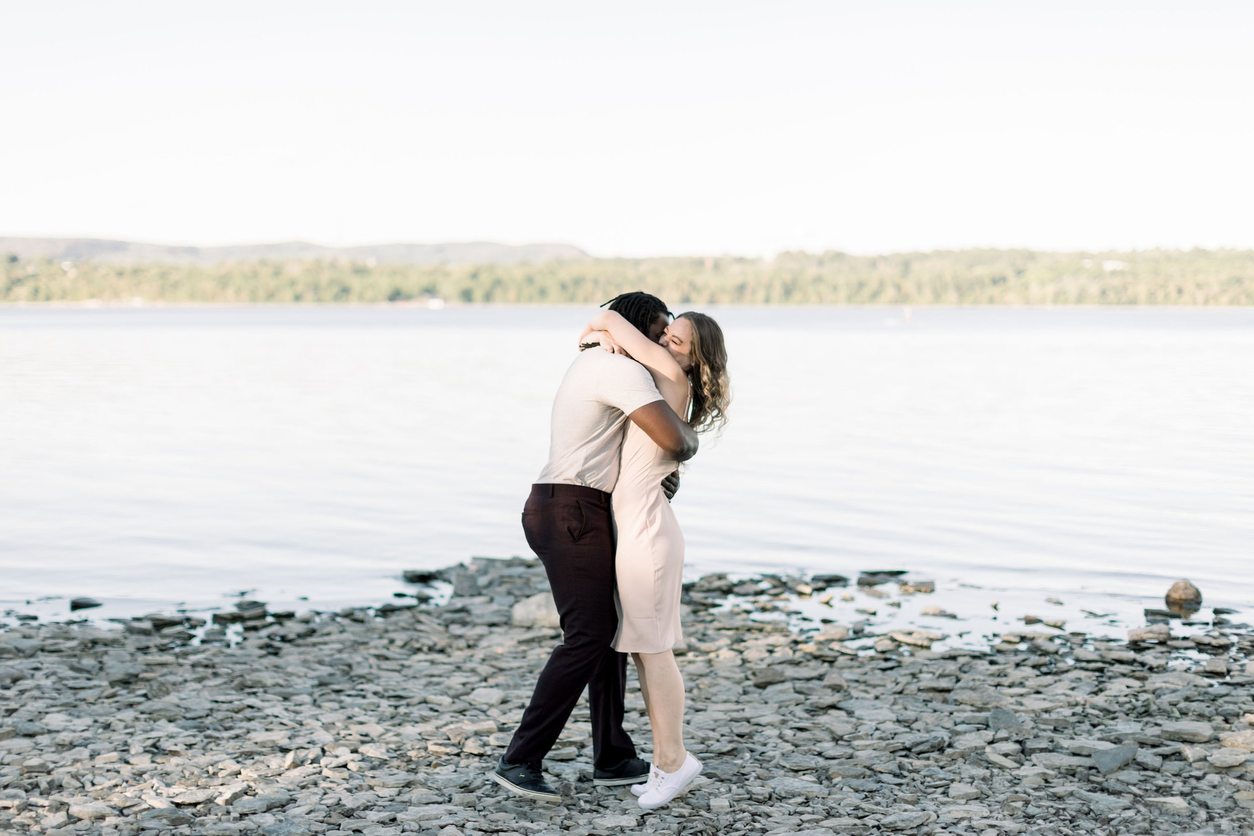  Next to a lake at Pinhey's Point Chelsea Mason Photography capture a newly engaged couple hugging. lake engagement inspiration #Chelseamasonphotography #Chelseamasonengagements #Onatarioengagements #Pinhey'sPoint #Ontarioweddingphotographers 