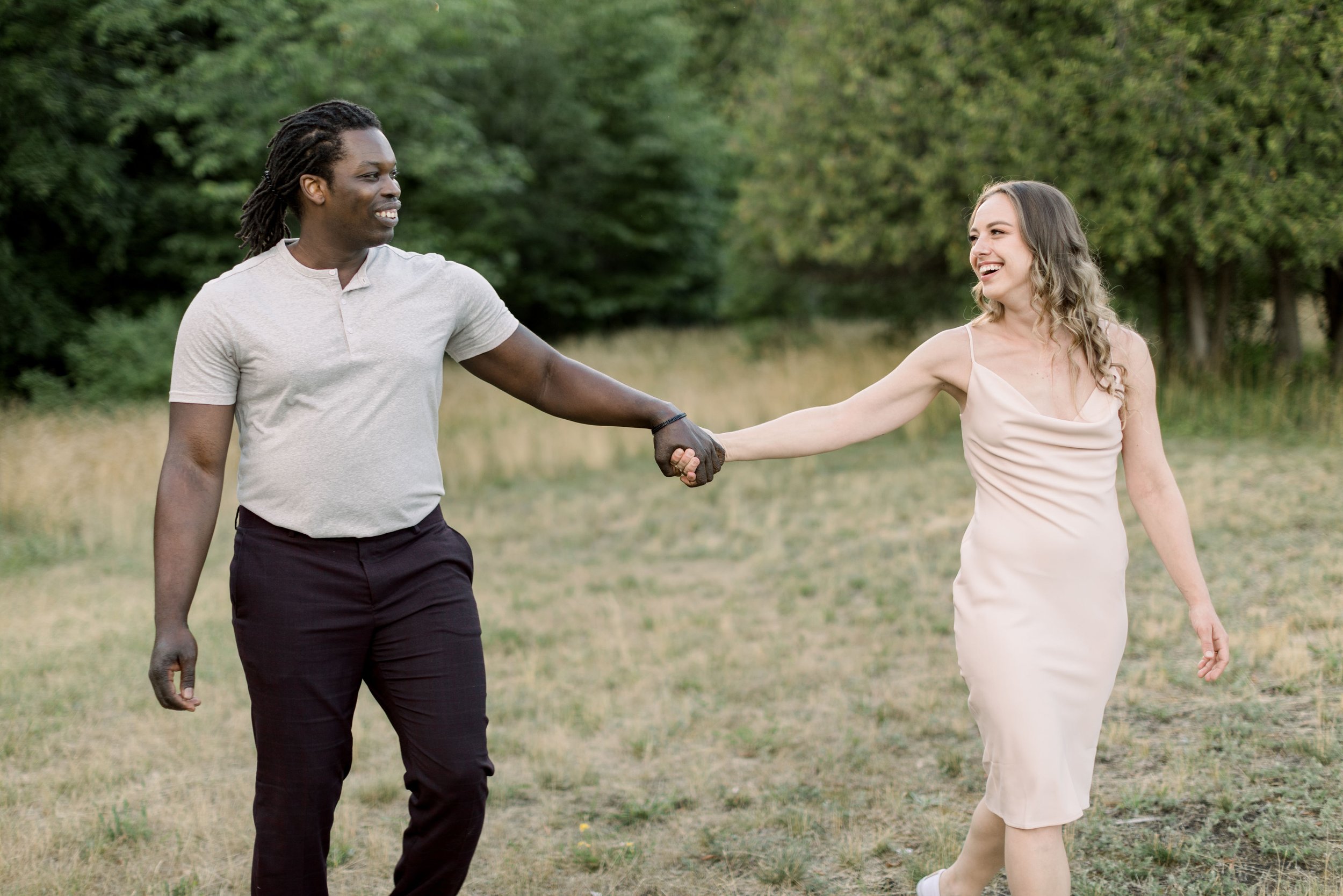  In Ontario Chelsea Mason Photography captures an engaged couple holding hands and smiling. casual engagement outfits black pants #Chelseamasonphotography #Chelseamasonengagements #Onatarioengagements #Pinhey'sPoint #Ontarioweddingphotographers 