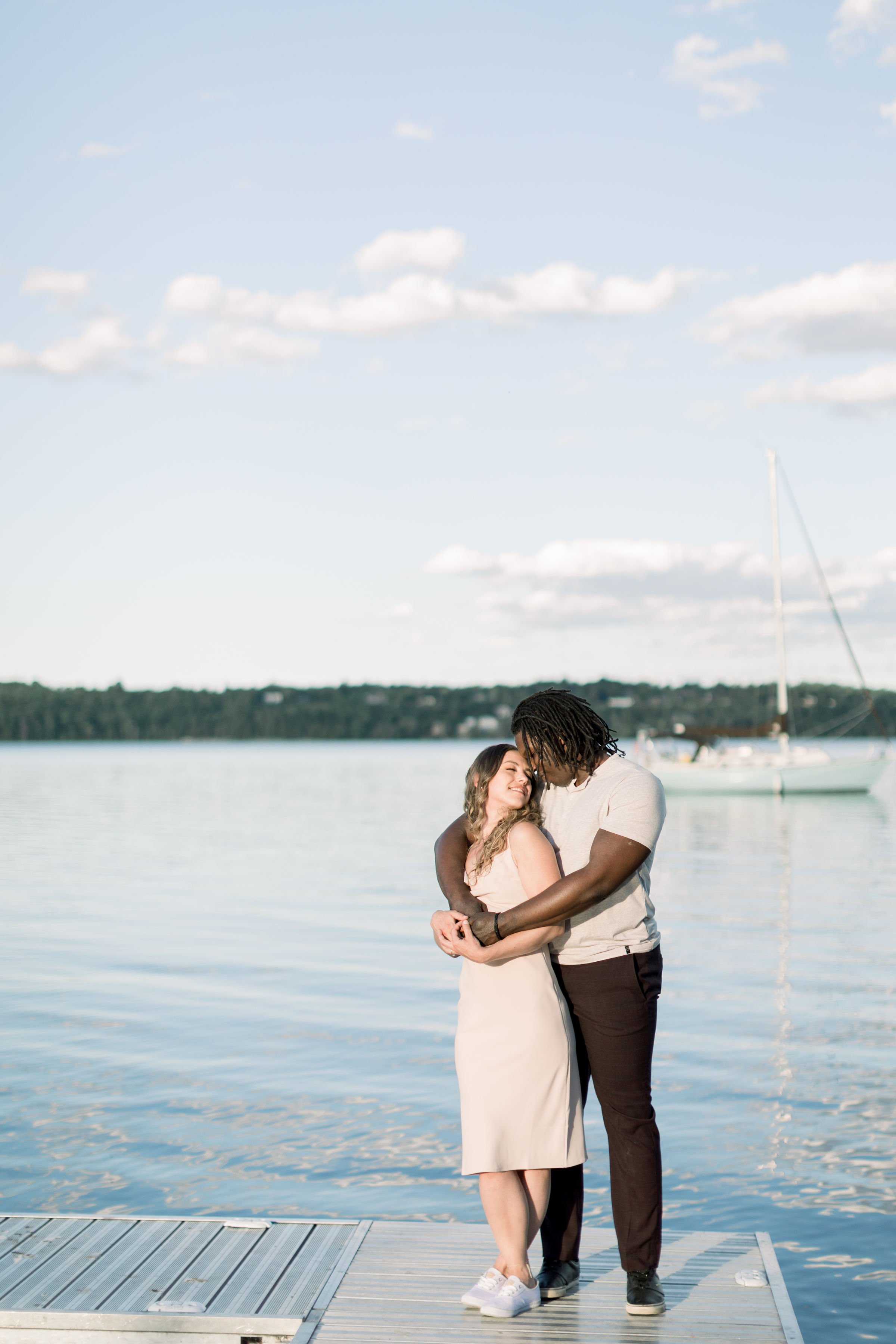  Lake engagement portraits with blue sky in Ontario by Chelsea Mason Photography. lake engagement portraits blue sky hugging #Chelseamasonphotography #Chelseamasonengagements #Onatarioengagements #Pinhey'sPoint #Ontarioweddingphotographers 