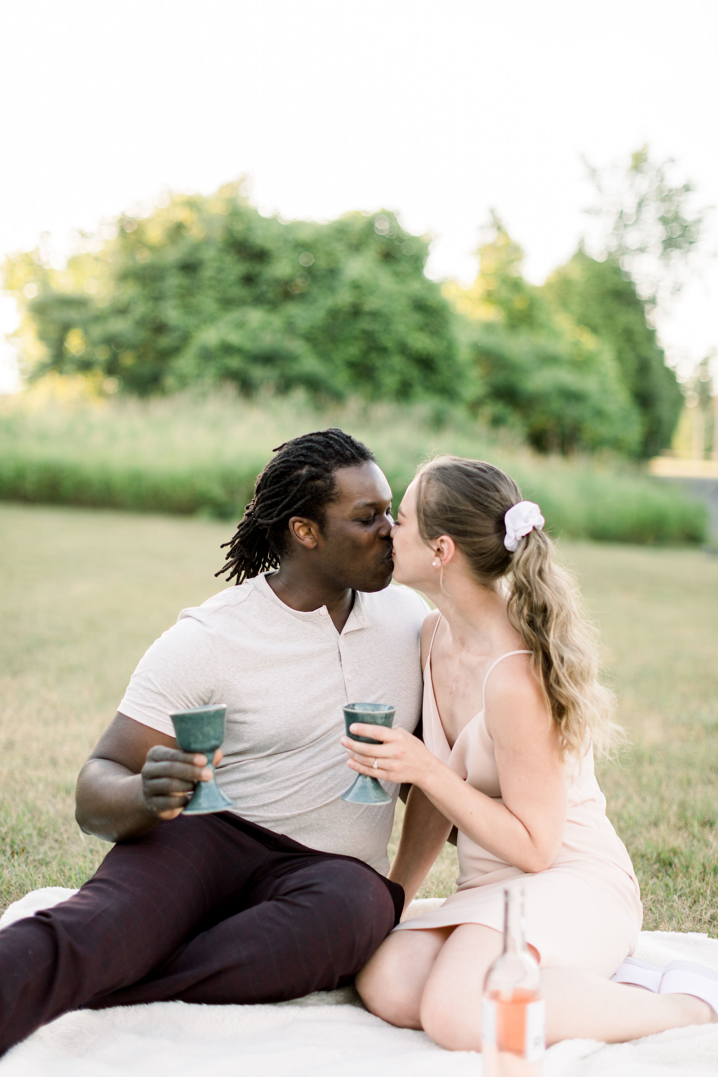  Newly engaged couple kiss with cups in their hand celebrating by Chelsea Mason Photography. kissing while drinking marriage goals #Chelseamasonphotography #Chelseamasonengagements #Onatarioengagements #Pinhey'sPoint #Ontarioweddingphotographers 