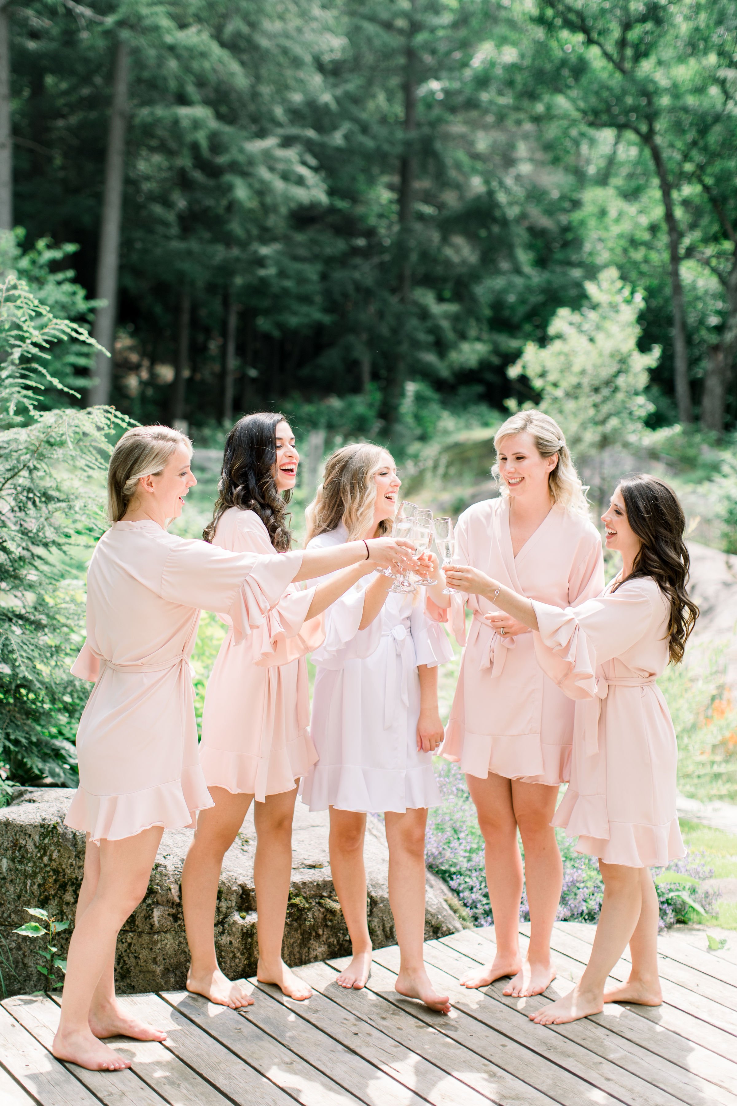  Bridemaids all clink their glasses together with the bride a Le Belvedere by Chelsea Mason Photography. champagne glass toast #Quebecweddings #elegantoutdoorwedding #Quebecweddingphotographers #Chelseamasonphotography #Chelseamasonweddings 