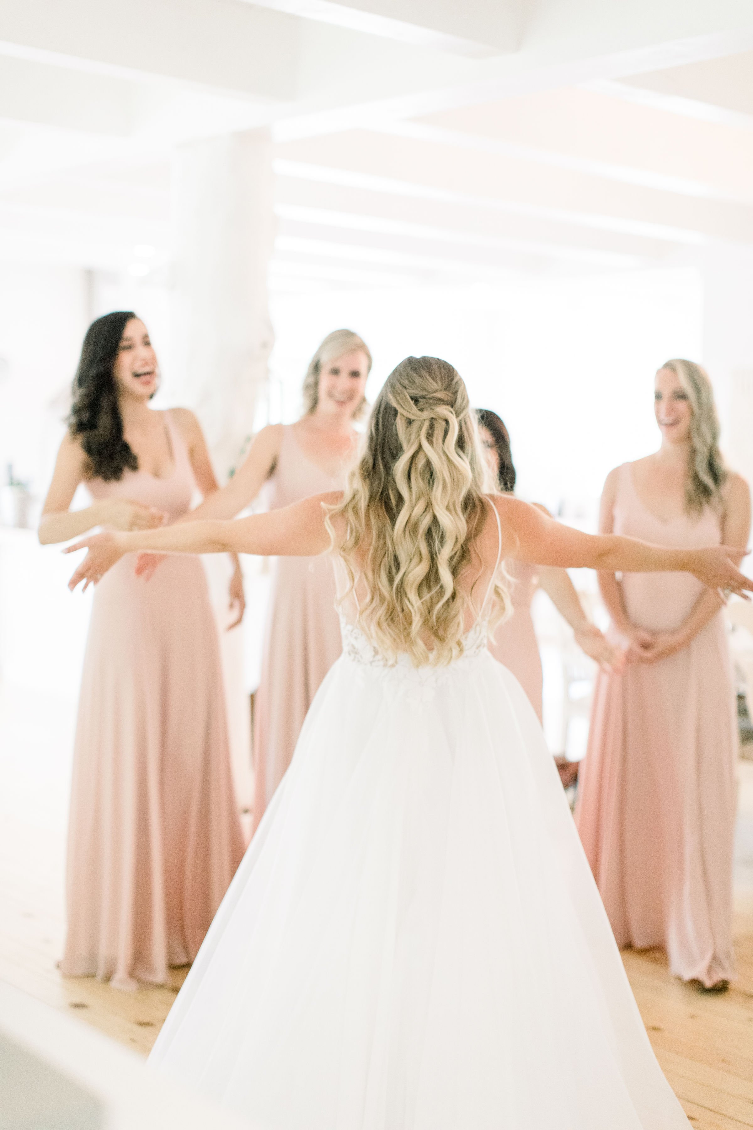  A bride shares a first look with her bridesmaids as they go in for a hug by Chelsea Mason Photography. hug the bridesmaids first look #Quebecweddings #elegantoutdoorwedding #Quebecweddingphotographers #Chelseamasonphotography #Chelseamasonweddings 