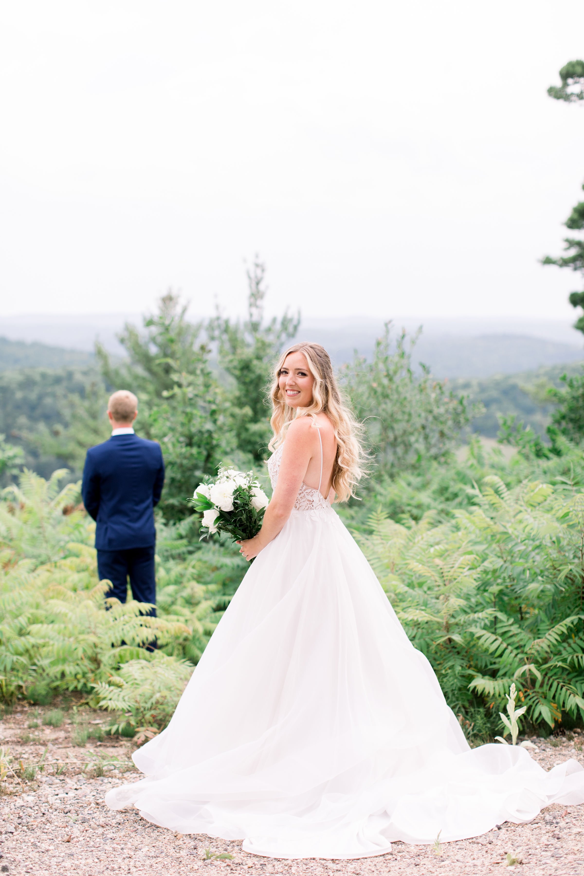  A bride stands behind a groom as he awaits the first look by Chelsea Mason Photography. first look with groom Quebec mountains #Quebecweddings #elegantoutdoorwedding #Quebecweddingphotographers #Chelseamasonphotography #Chelseamasonweddings 